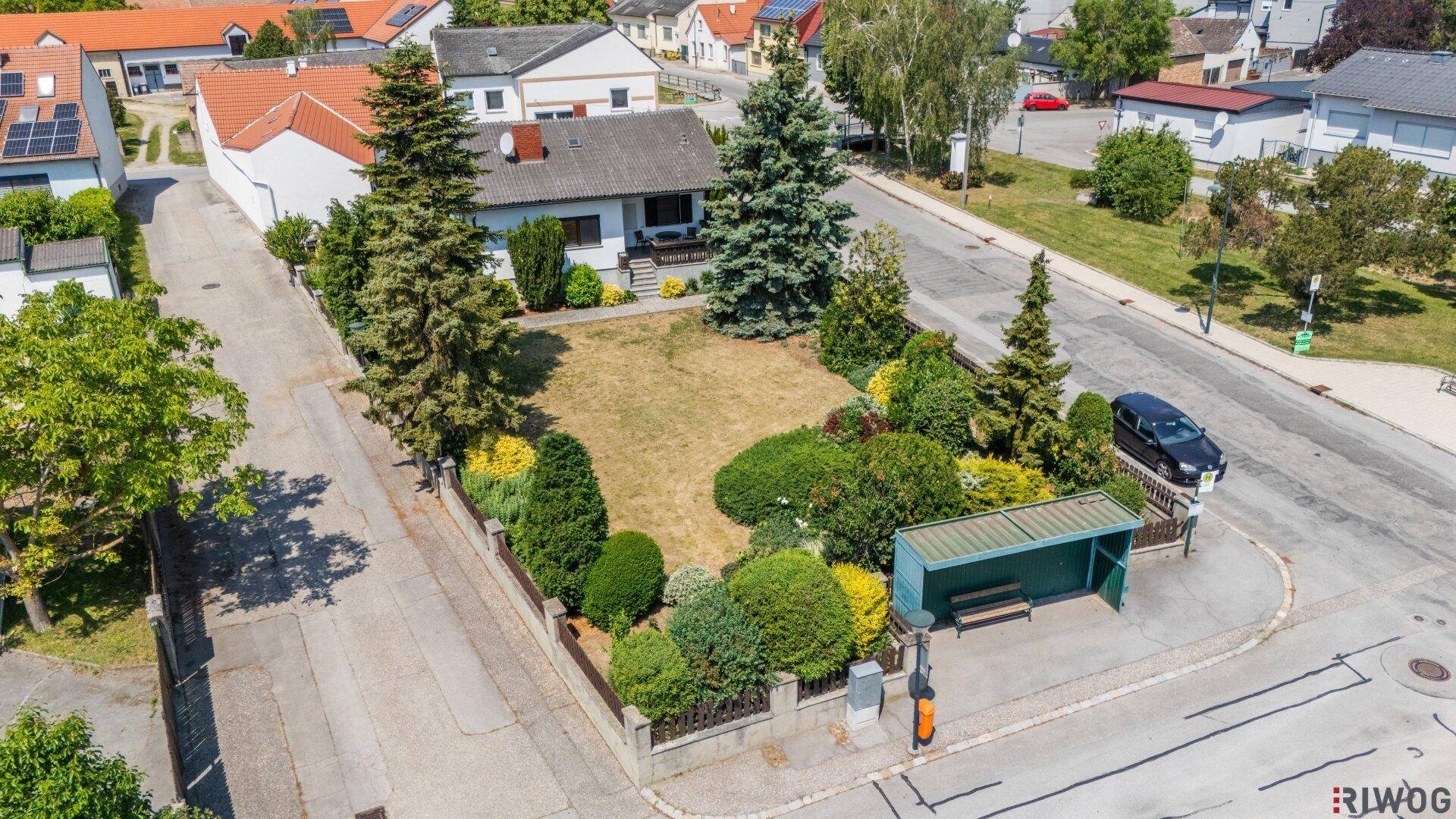 Weitläufige Luftaufnahme eines Einfamilienhauses mit großem Garten und umliegender Wohnbebauung.