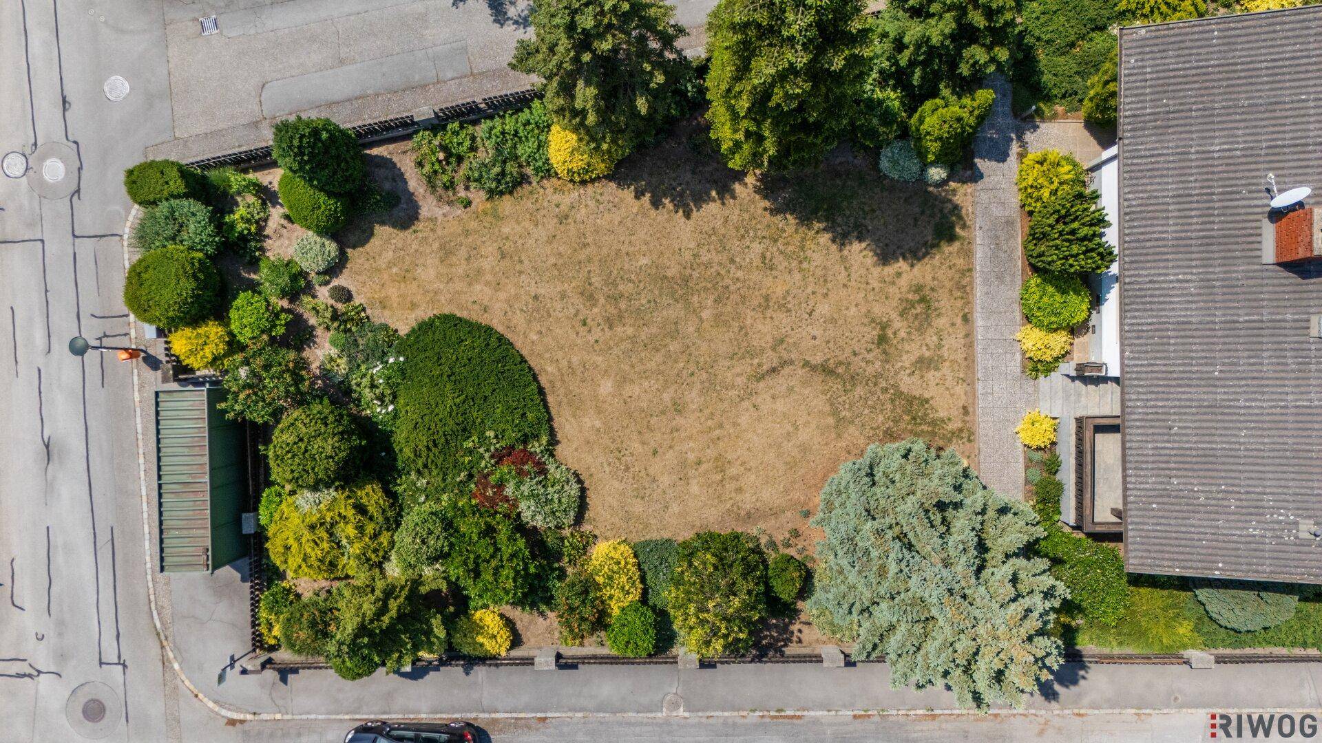 Draufsicht auf das Grundstück mit großem Garten, Rasenfläche und üppiger Bepflanzung.