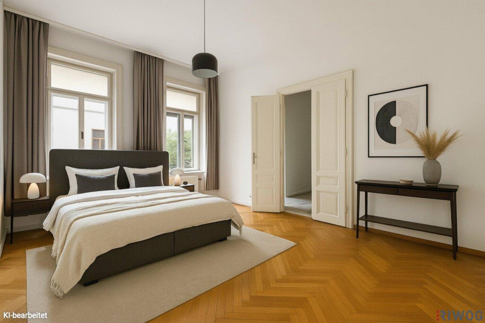 Geräumiges Schlafzimmer mit Doppelbett, Fischgrätparkett und hohen Fenstern.