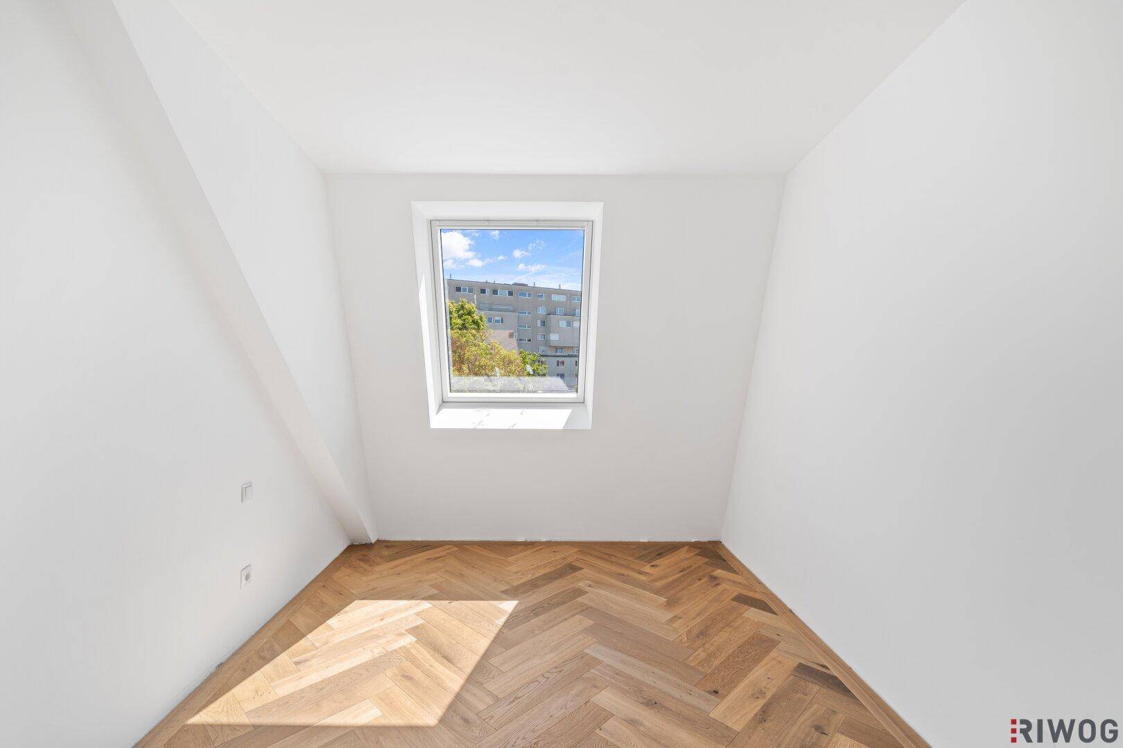 Gemütliches Zimmer mit Dachfenster und Fischgrätparkett, ideal als Kinder- oder Arbeitszimmer.