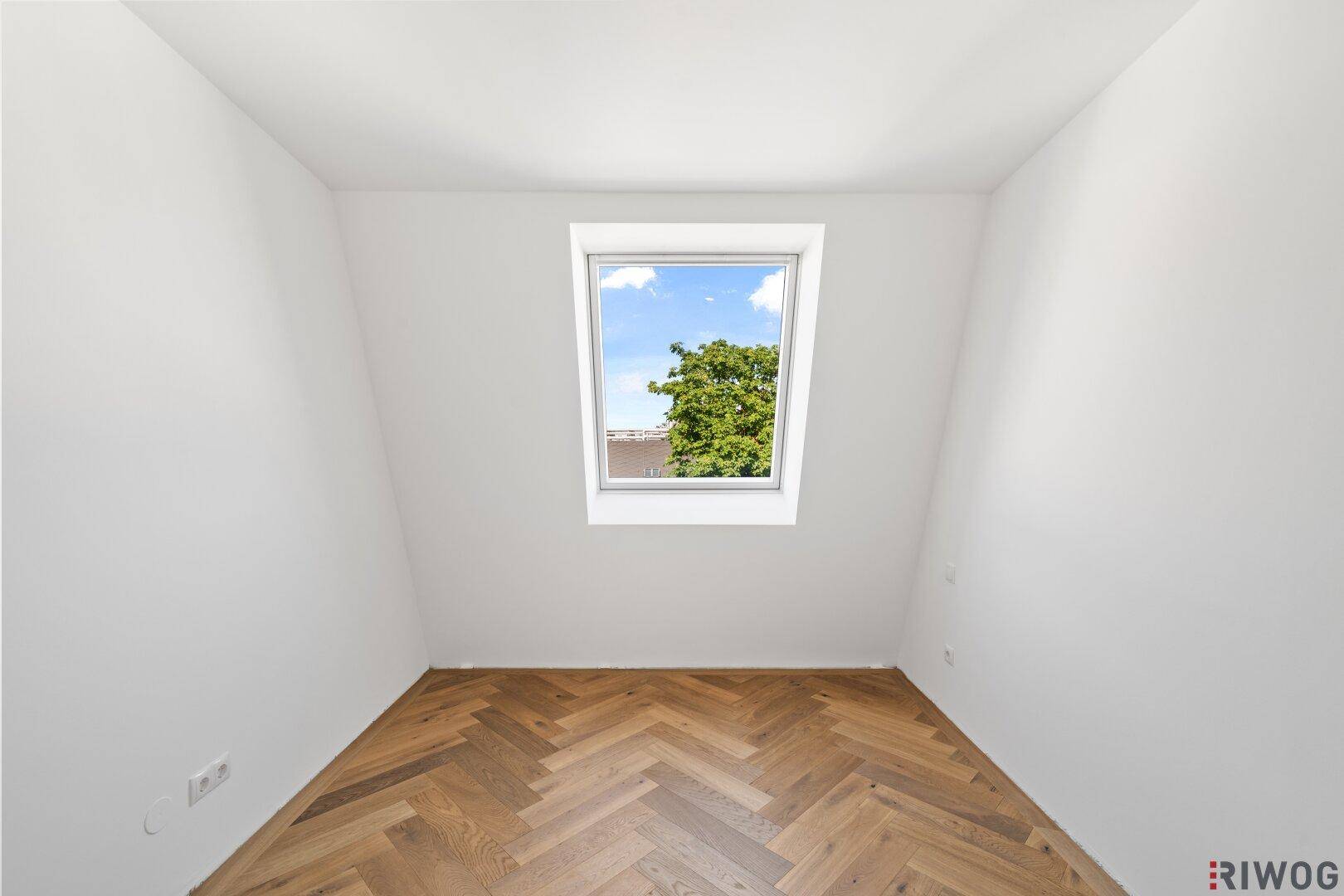 Gemütliches Zimmer mit Dachfenster und Fischgrätparkett, ideal als Kinder- oder Arbeitszimmer.