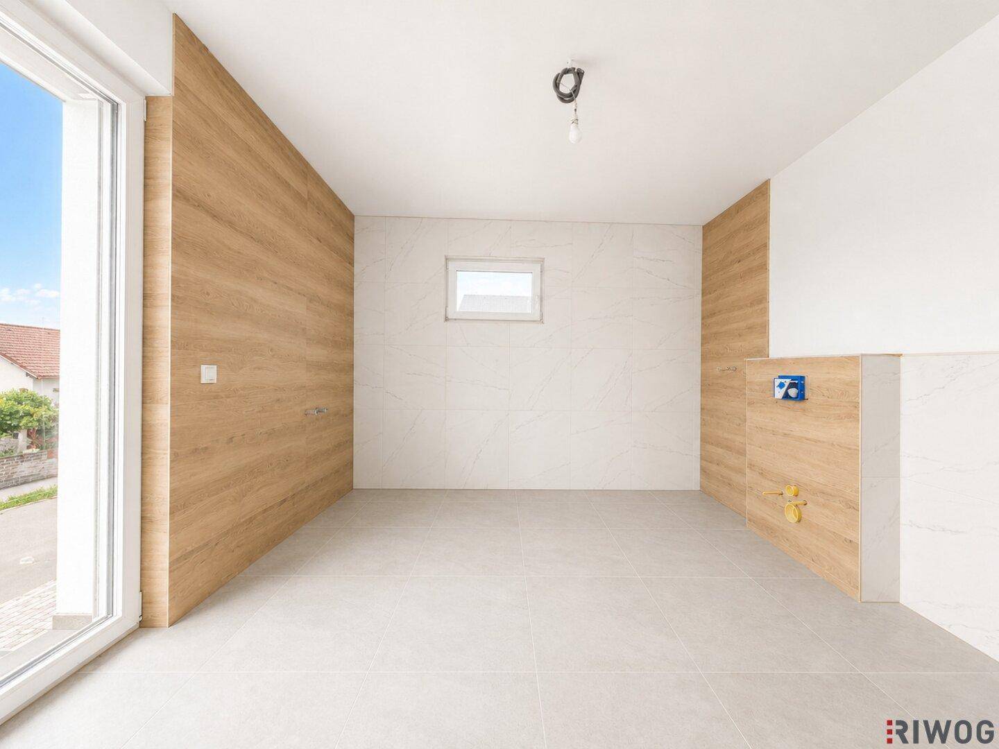 Unfertiges Badezimmer mit Fliesenboden, Holzverkleidung und Fenster, bereit für die Installation.