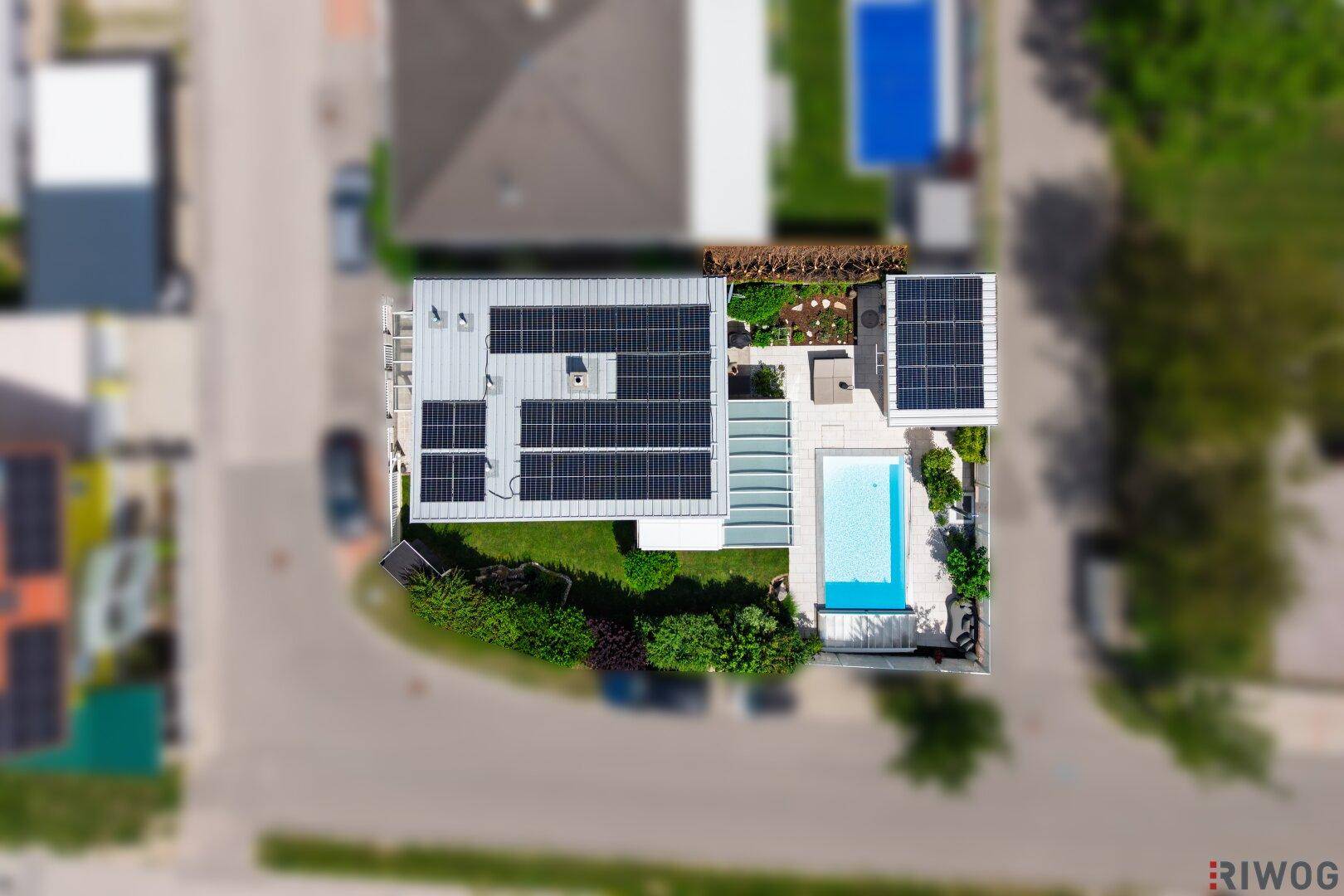 Luftaufnahme des Hauses mit Pool, Solaranlagen auf dem Dach und Gartenanlage.