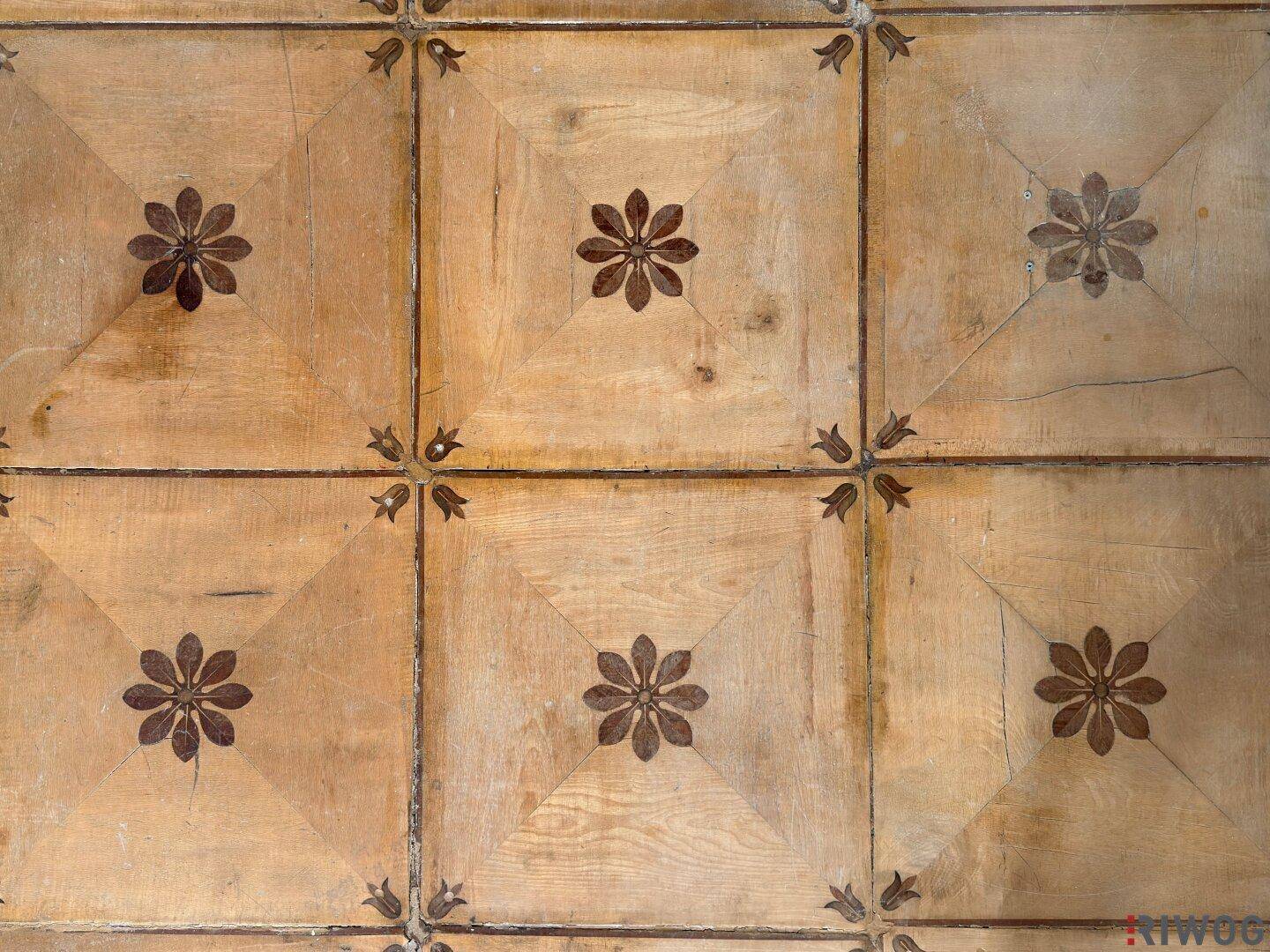 Detailaufnahme eines gemusterten Fliesenbodens mit floralen Motiven, traditioneller Stil.