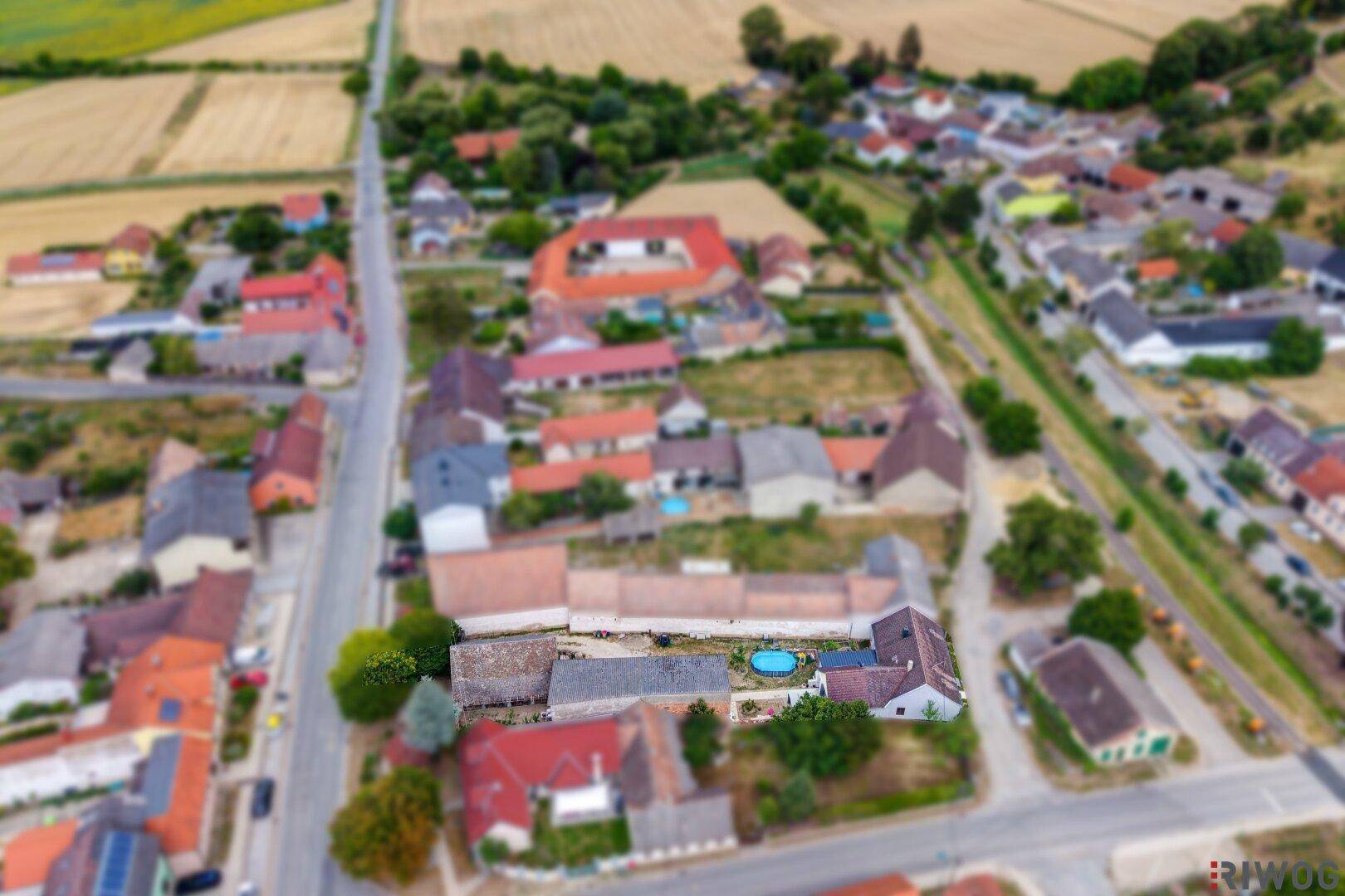 Weitläufige Luftaufnahme des Dorfes mit dem Anwesen und den umliegenden landwirtschaftlichen Flächen.