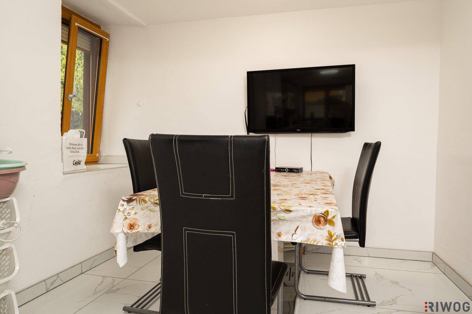 Gemütlicher Essbereich mit Tisch und Stühlen, direkt am Fenster gelegen.
