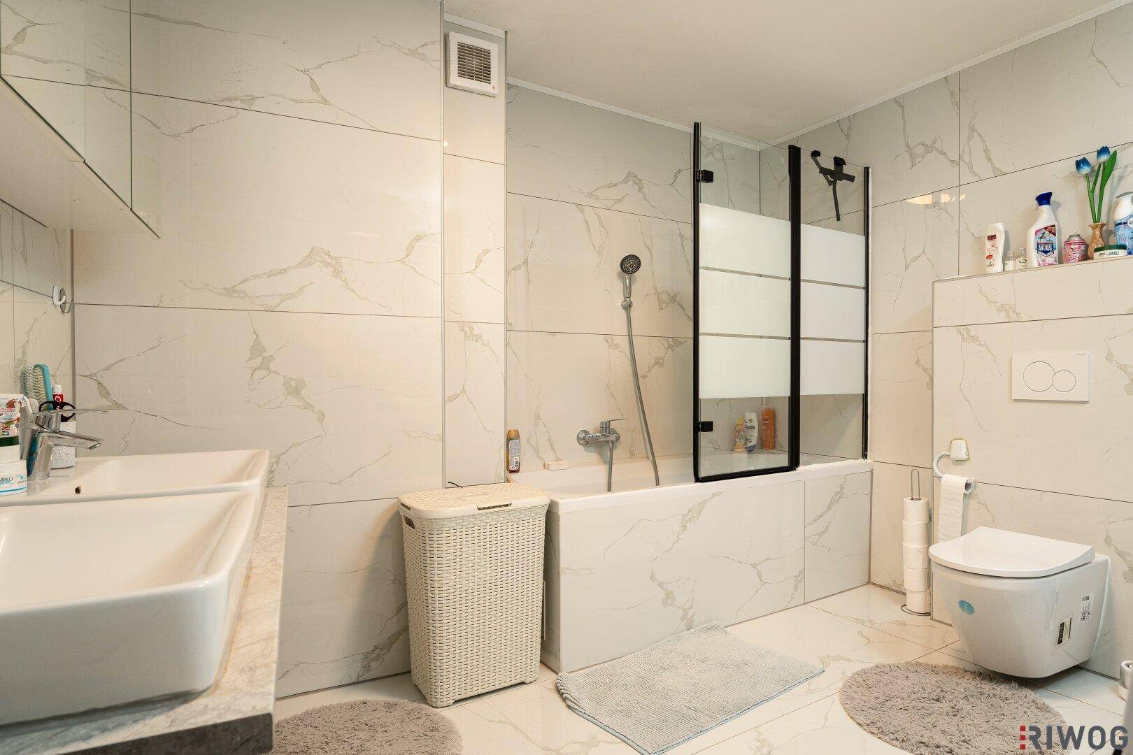 Geräumiges Badezimmer mit Badewanne, Duschabtrennung, Toilette und Doppelwaschbecken.