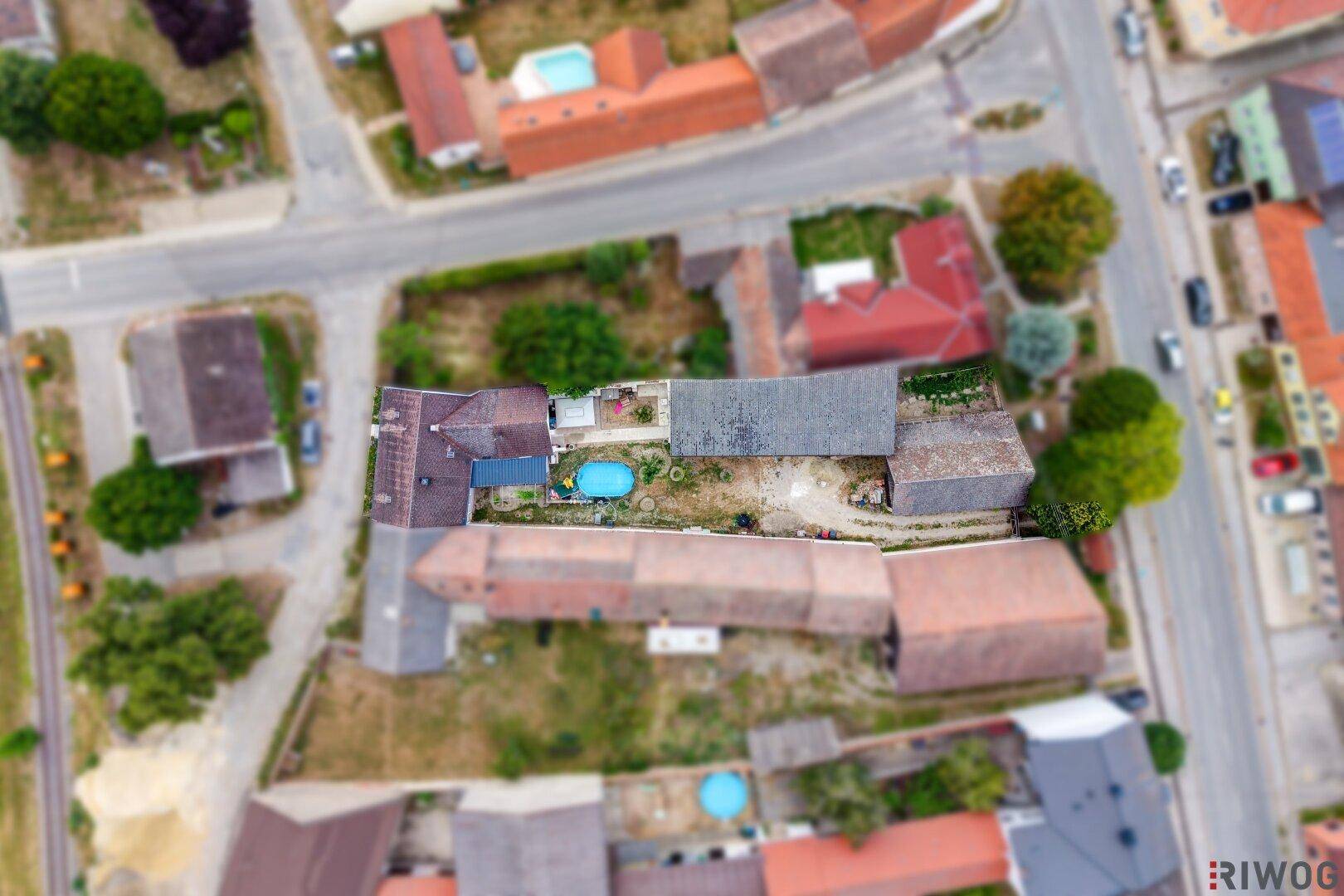 Senkrechte Luftaufnahme des Grundstücks mit Wohnhaus, Nebengebäuden und einem kleinen Pool.