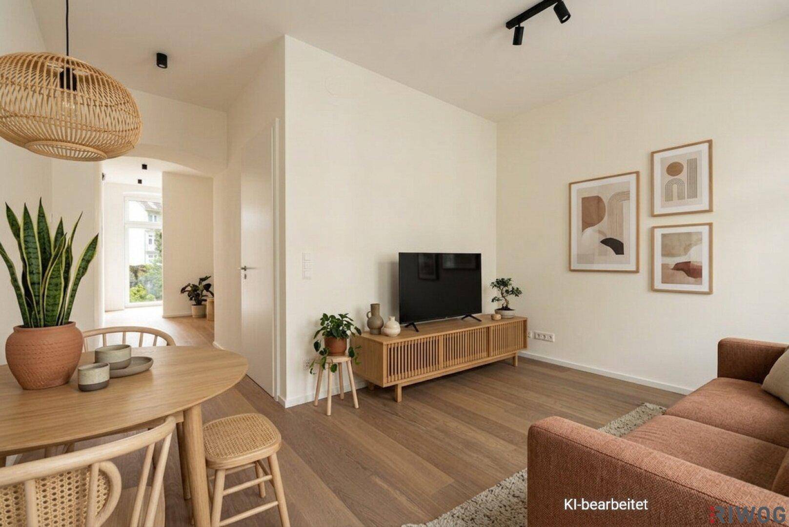 Gemütlicher Wohn- und Essbereich mit Holzboden, modernem Sofa und Blick in den Flur.