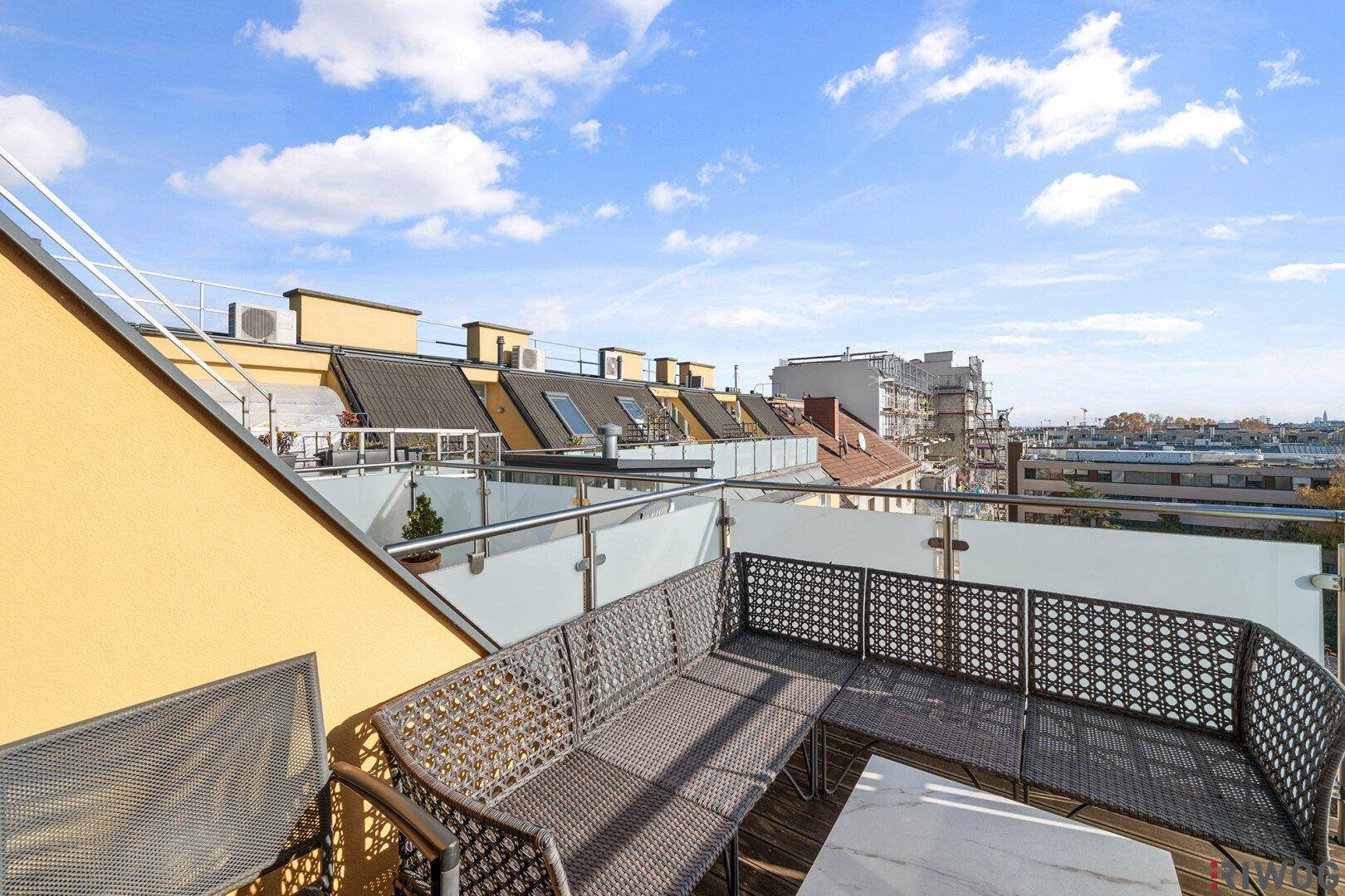 Geräumige Dachterrasse mit Sitzgelegenheiten und weitem Blick über die Stadt.