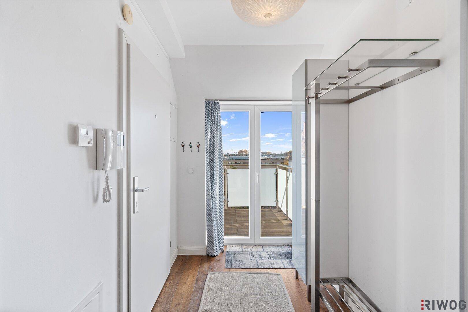 Heller Eingangsbereich mit Garderobe und Zugang zur Dachterrasse.