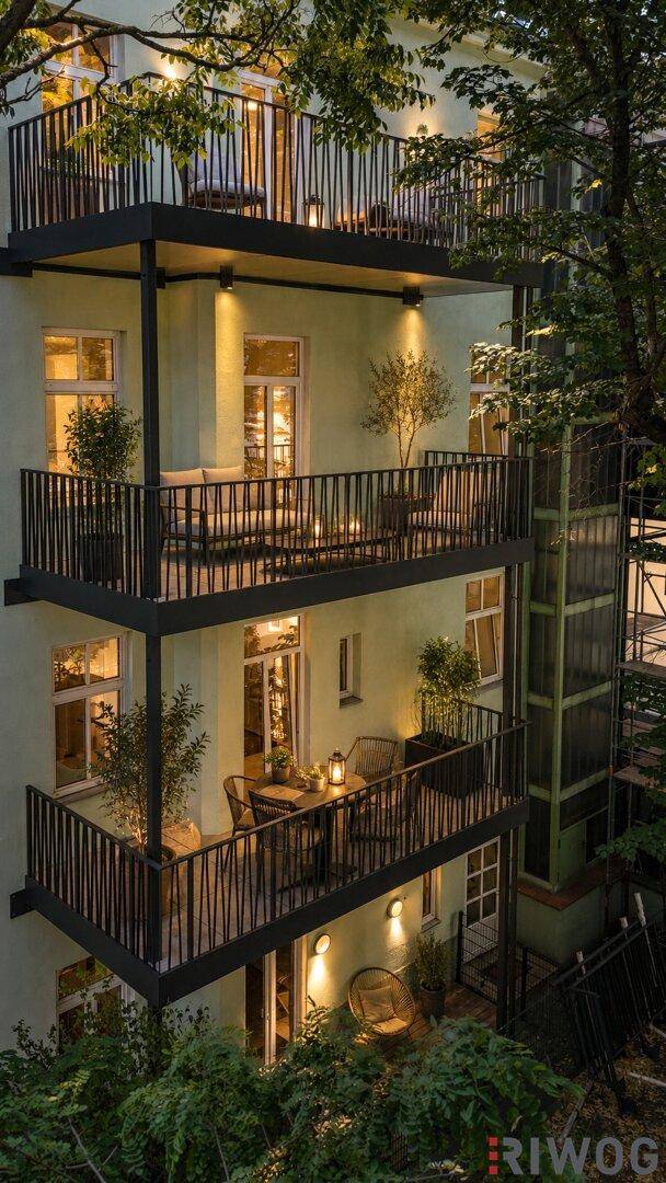 Vertikale Ansicht der beleuchteten Balkone und Terrassen des Gebäudes bei Nacht mit Sitzgelegenheiten.