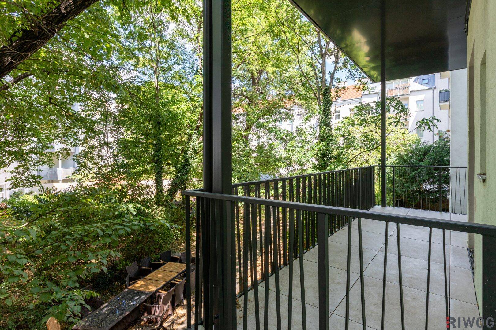 Geräumiger Balkon mit Fliesenboden und weitem Blick ins Grüne.