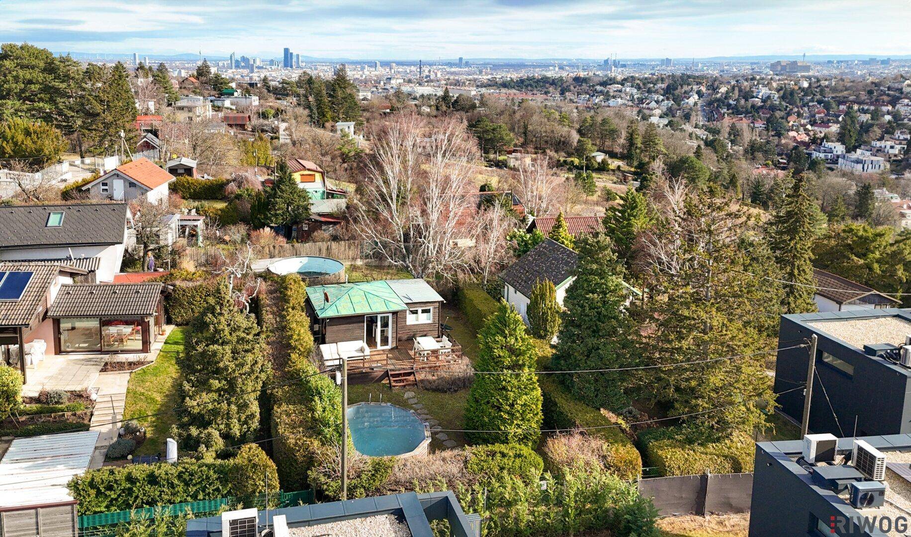 Weitläufiger Blick auf das Anwesen mit Garten, Pool und der umliegenden Wohngegend.