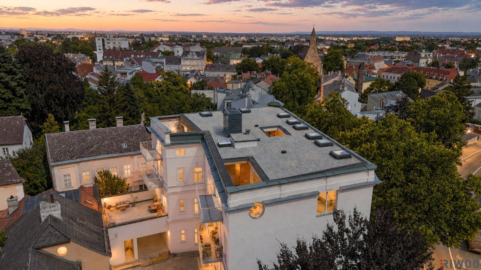 Draufsicht auf ein modernes Gebäude mit Flachdach und Blick auf die umliegende Stadtlandschaft.