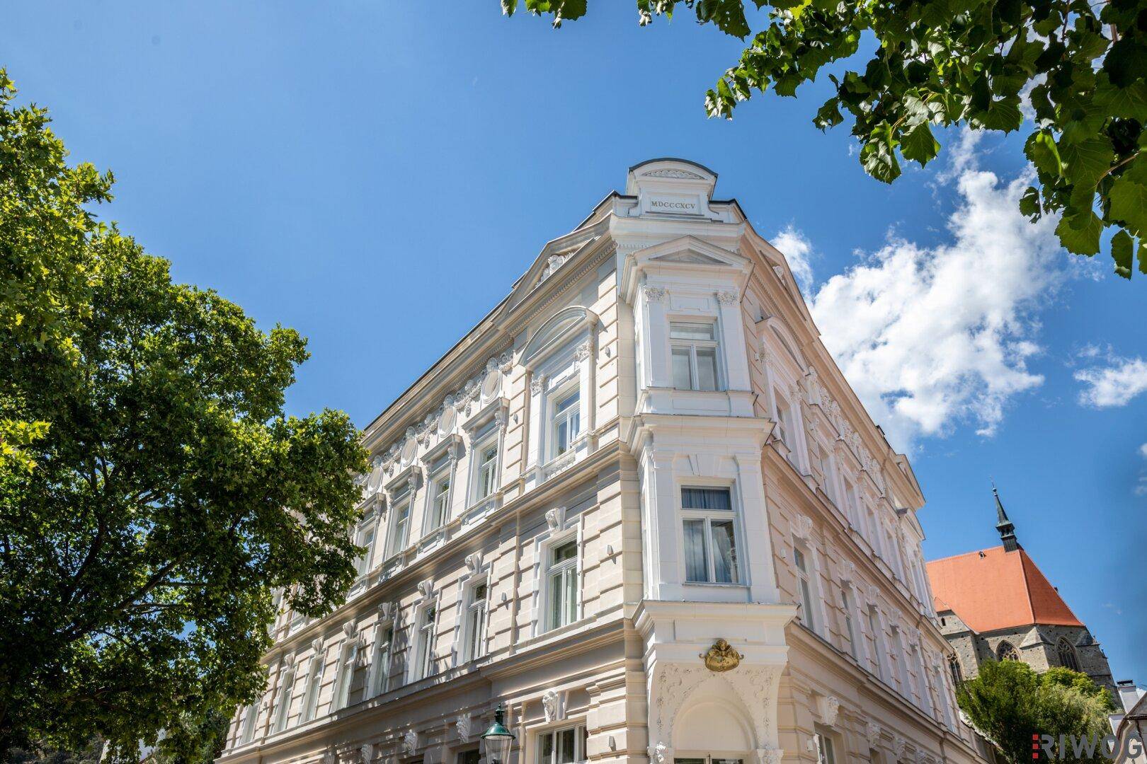 Detailansicht der prächtigen weißen Fassade eines historischen Gebäudes an einem sonnigen Tag.