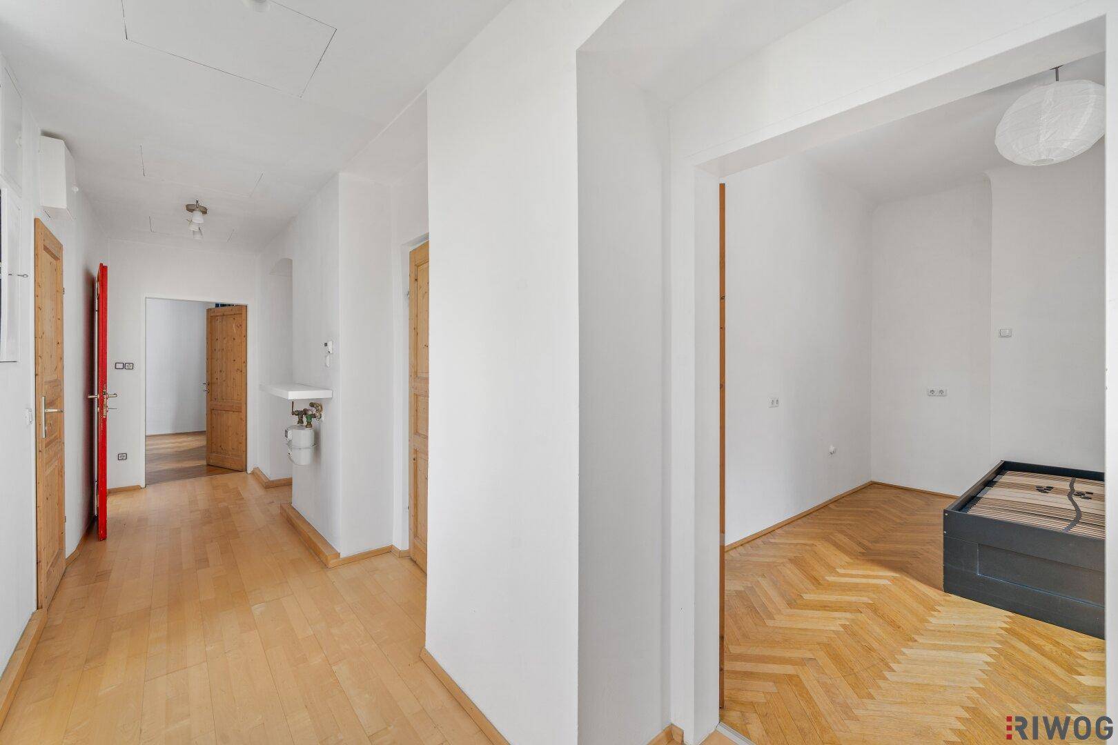 Langer Flur mit Holzboden und mehreren Türen, der verschiedene Räume verbindet.