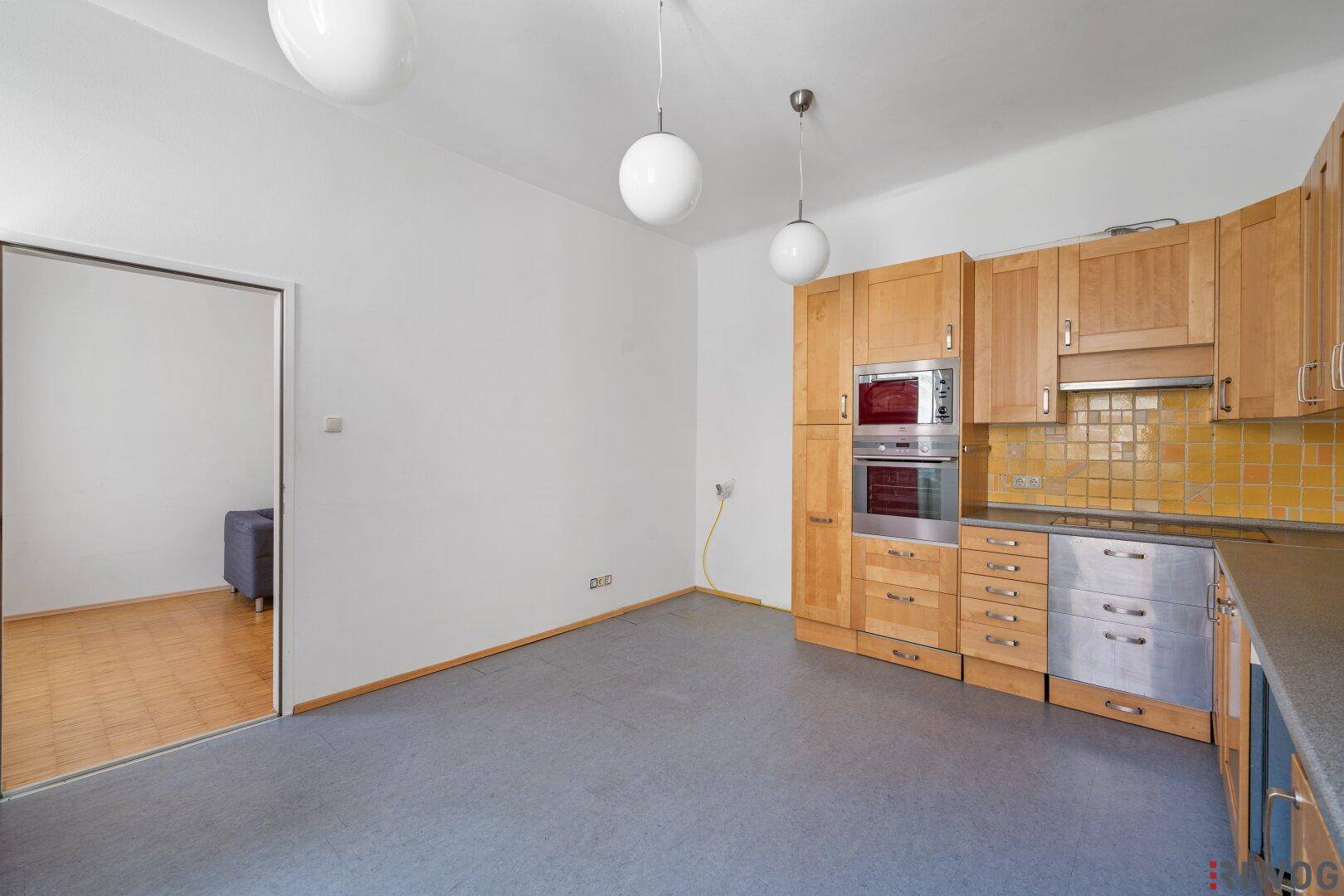 Geräumige Küche mit Holzschränken, gelben Fliesen und integrierten Elektrogeräten.