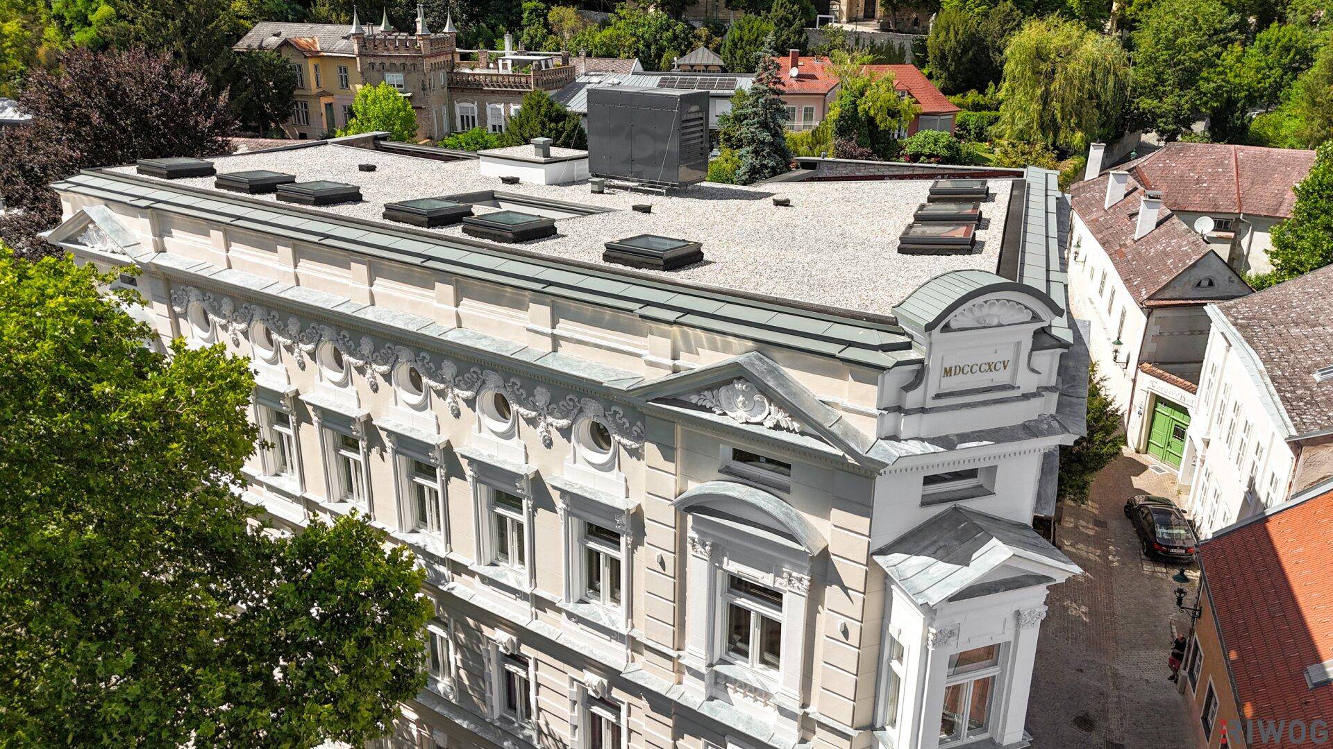 Tageslicht-Luftaufnahme des historischen Gebäudes mit seiner verzierten Fassade und dem Flachdach.