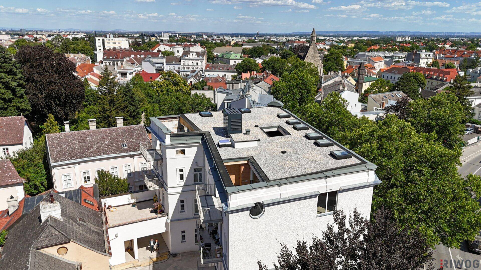 Luftaufnahme des Gebäudes mit Flachdach und weitem Blick über die Stadtlandschaft.