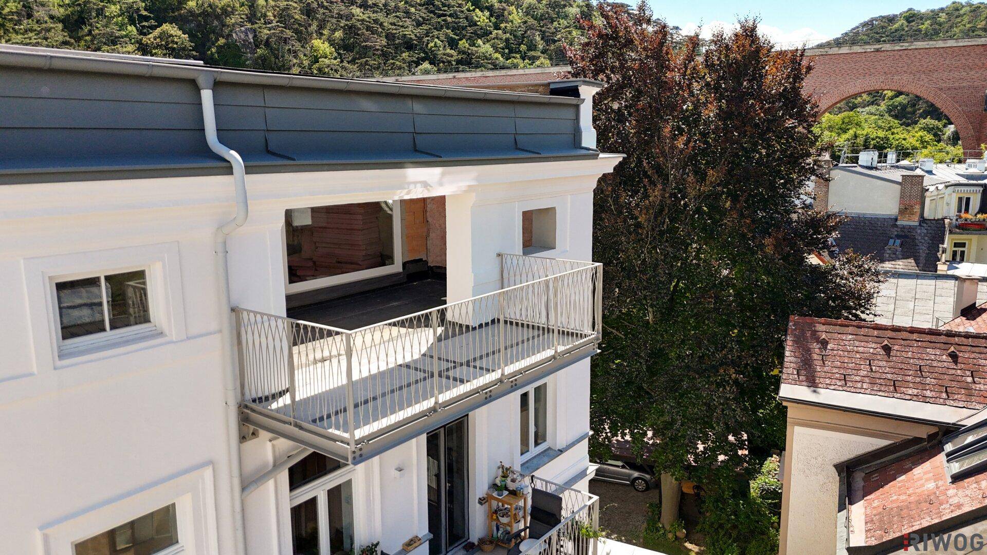Neuer Balkon im Bau mit Metallgeländer und Blick auf die umliegende grüne Landschaft.
