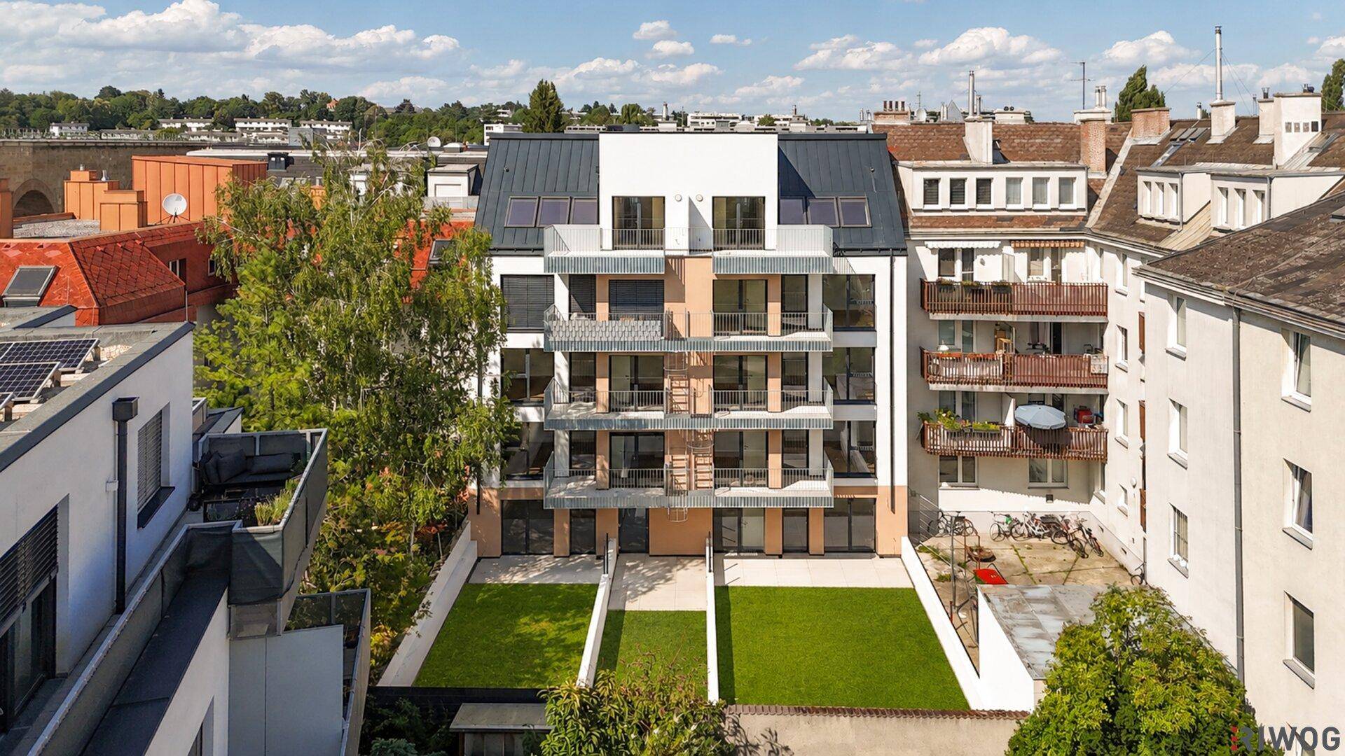 Modernes Apartmentgebäude mit privaten Gärten im Erdgeschoss und Balkonen in den oberen Etagen.