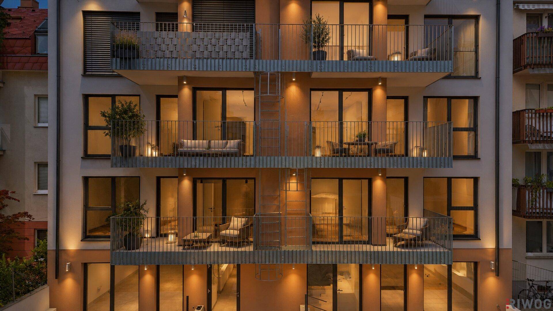 Beleuchtete Balkone des modernen Apartmentgebäudes bei Nacht, mit gemütlichen Sitzbereichen.