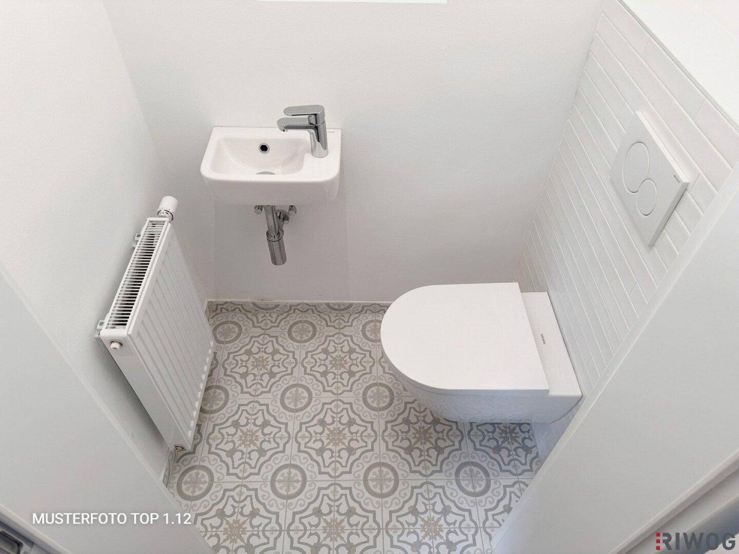 Kleines Gäste-WC mit modernem Wand-WC, Waschbecken und dekorativen Bodenfliesen.