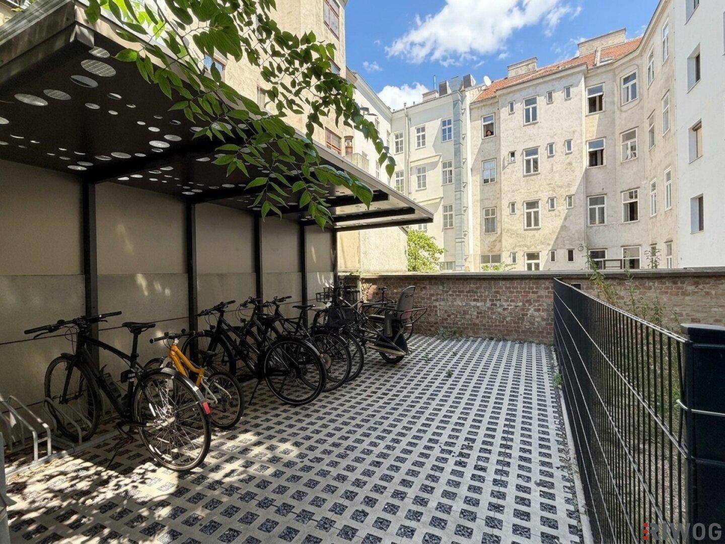 Überdachter Fahrradabstellplatz im Innenhof eines Wohngebäudes.