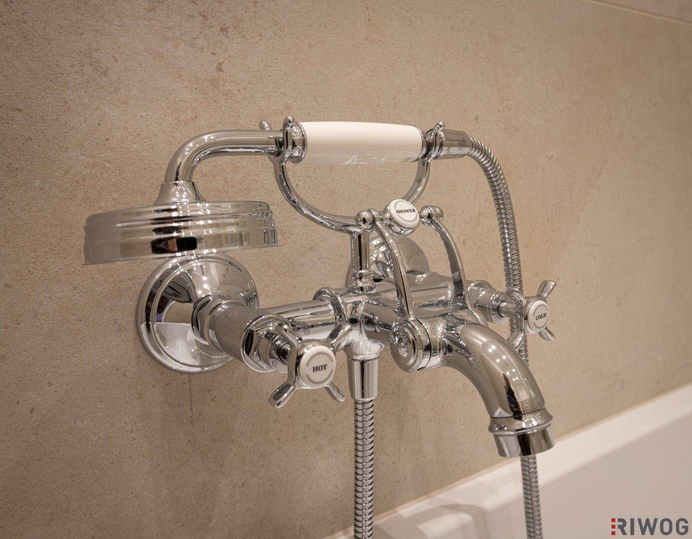 Detailaufnahme einer klassischen Armatur mit Handbrause im Badezimmer, die Eleganz verleiht.