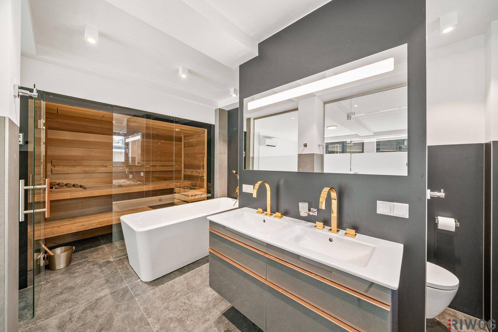 Luxuriöses Badezimmer mit integrierter Sauna, freistehender Badewanne und Doppelwaschbecken.