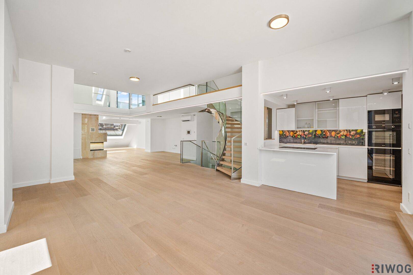 Geräumiger offener Wohnbereich mit moderner Küche und eleganter Wendeltreppe.