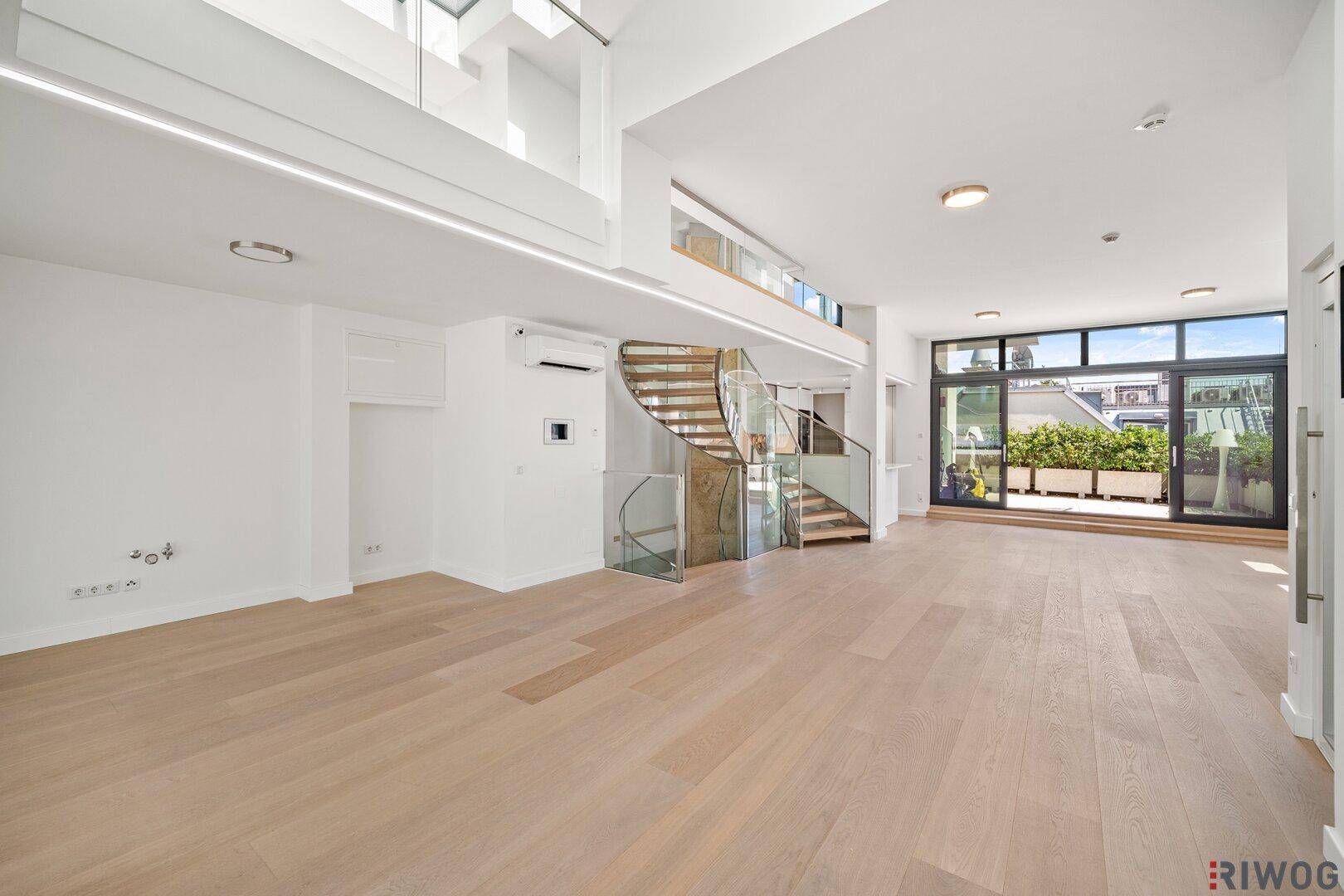 Großer offener Wohnbereich mit Wendeltreppe, Zugang zur Terrasse und Klimaanlage.