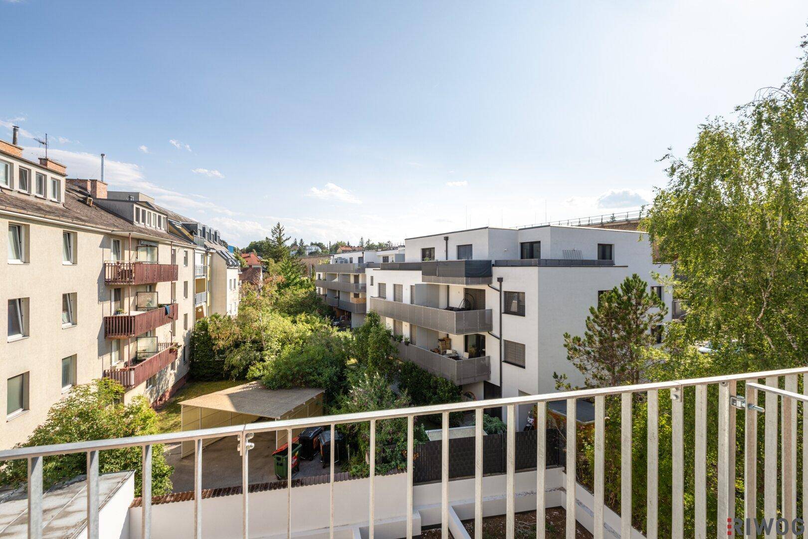 Blick vom Balkon auf die umliegenden Wohngebäude und die grüne Umgebung der Nachbarschaft.