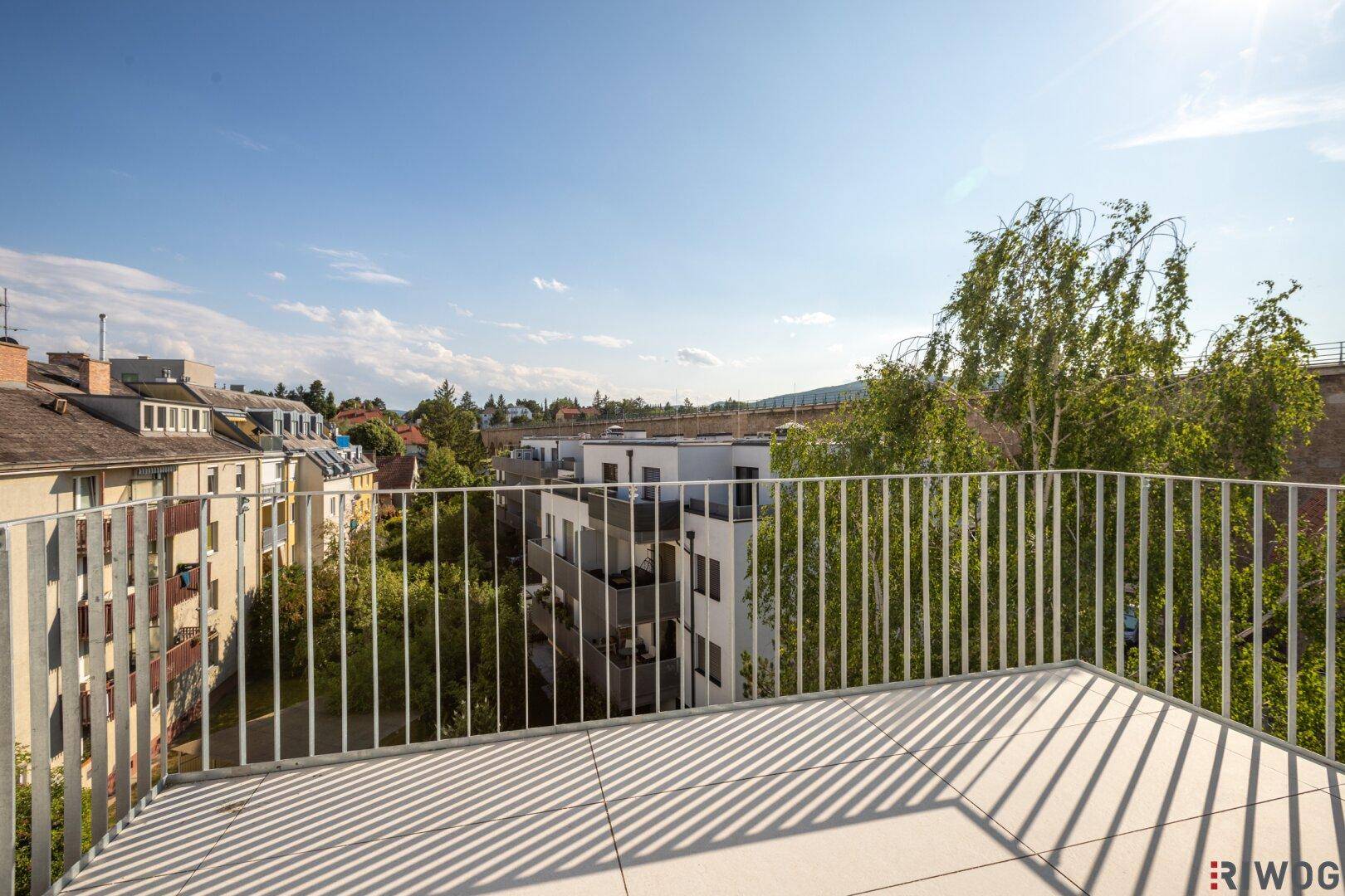 Weitläufige Dachterrasse mit Panoramablick über die Stadt und viel Sonnenschein an einem klaren Tag.