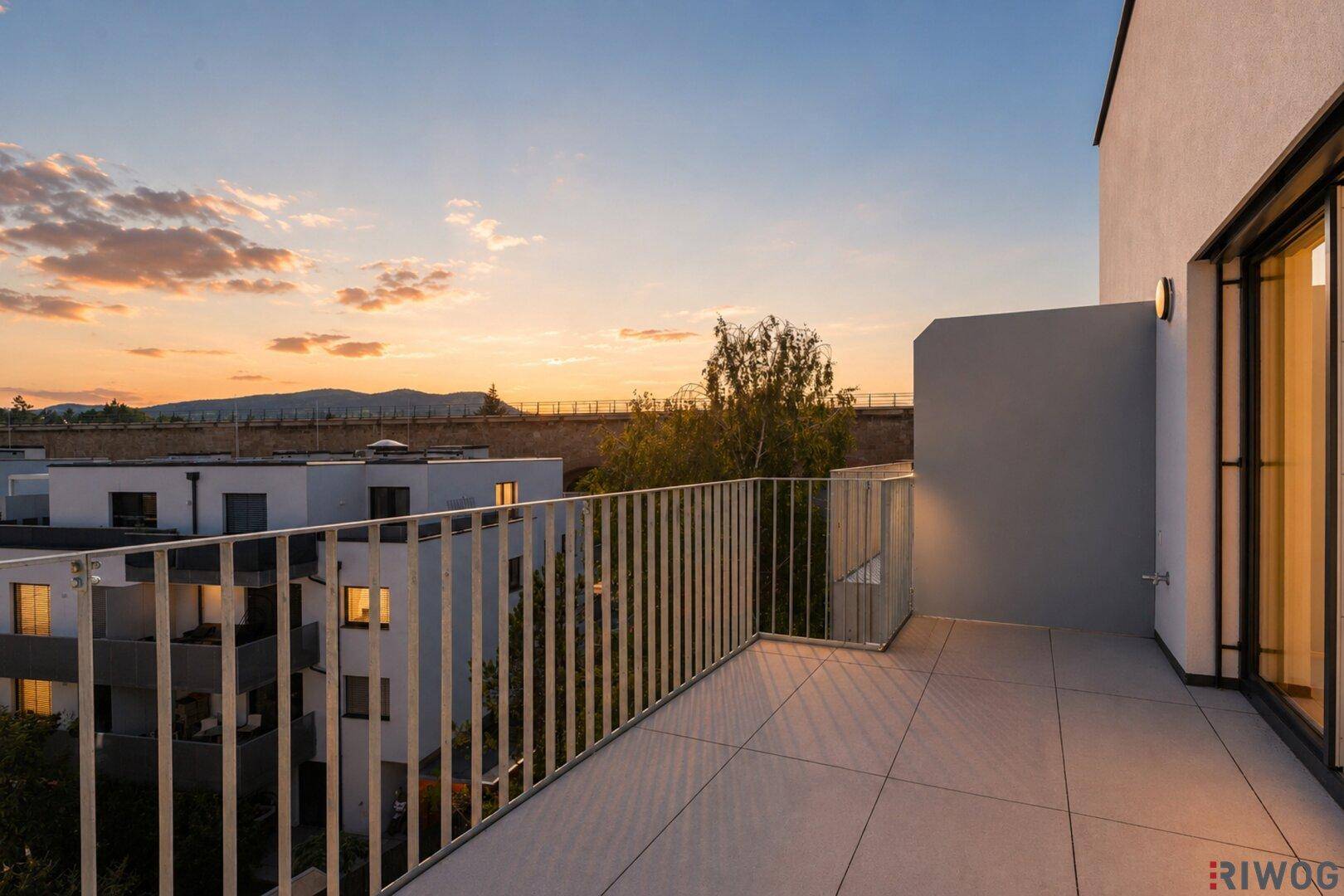 Geräumiger Balkon mit moderner Brüstung und Blick auf die umliegenden Gebäude.