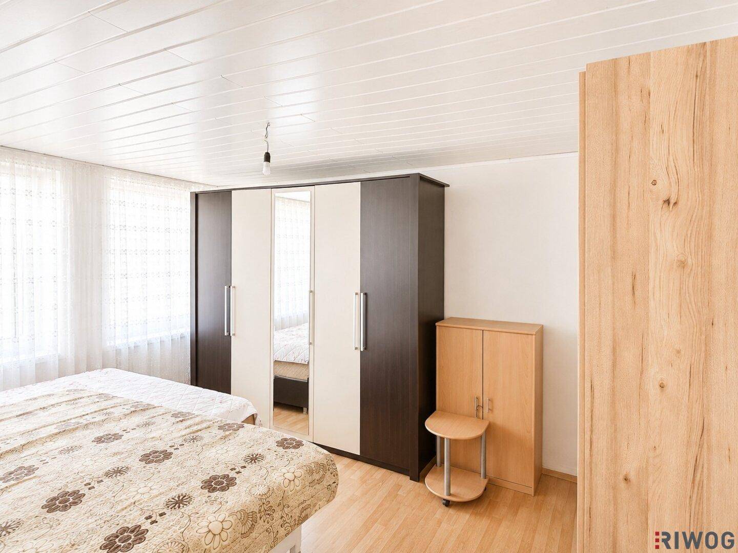 Geräumiges Schlafzimmer mit hellem Holzboden und großen Kleiderschränken, die viel Stauraum bieten.