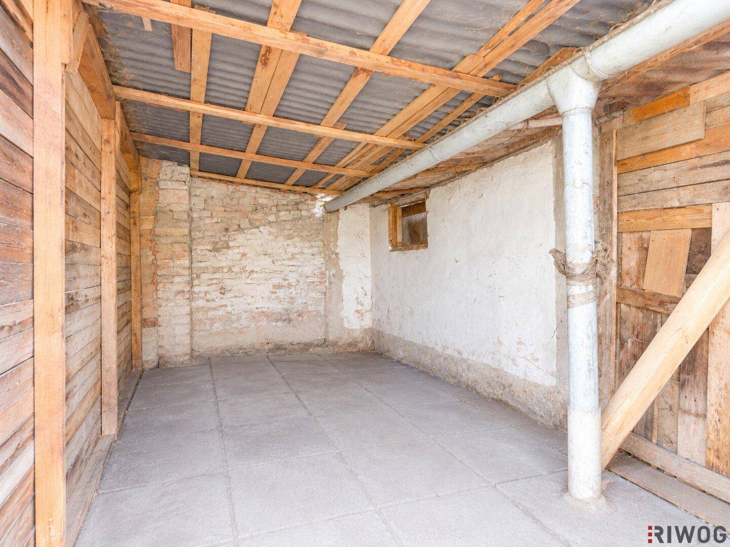 Unausgebauter Lagerraum mit Ziegelwänden und Betonboden, bietet viel Potenzial.