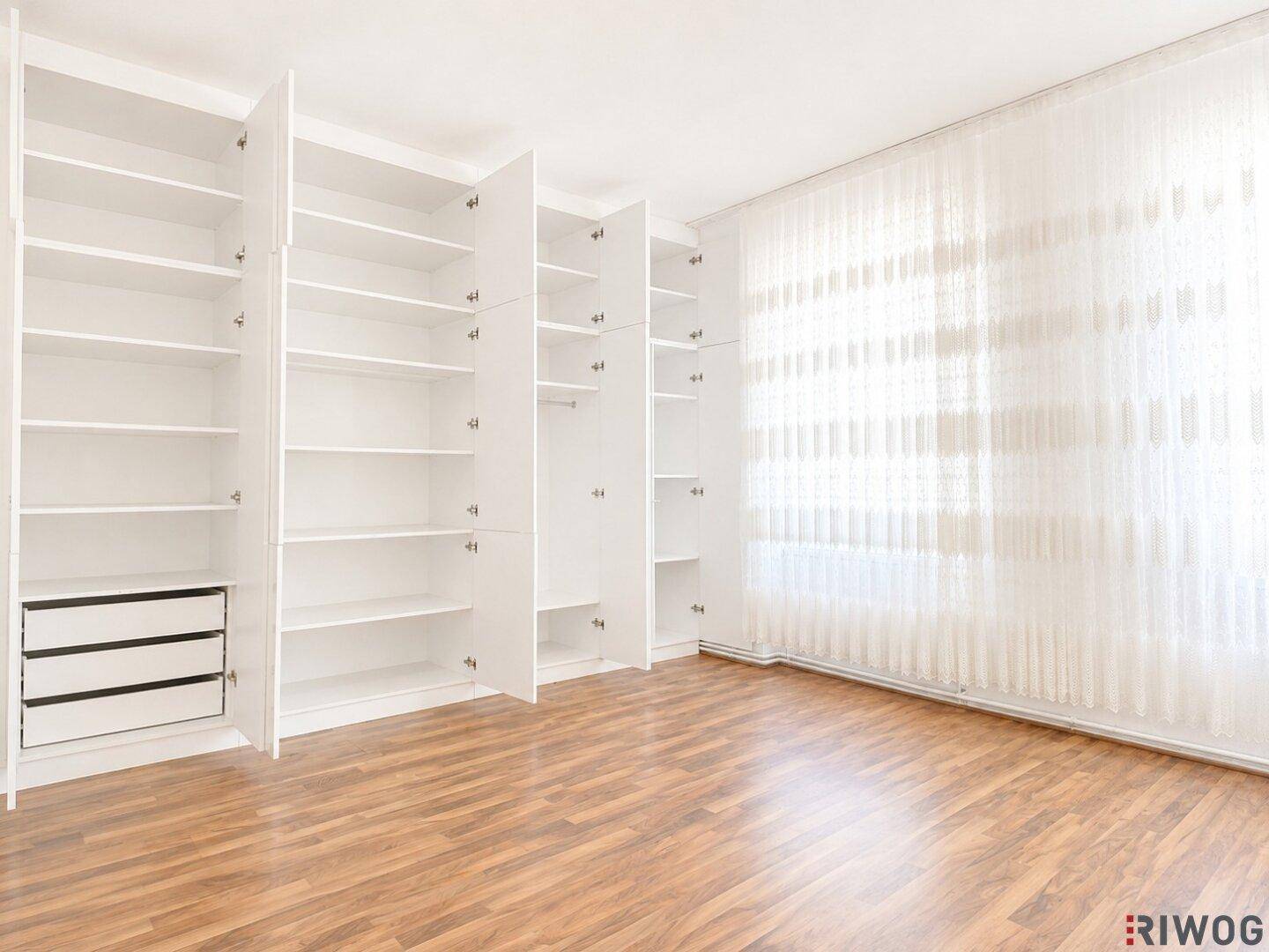 Heller Raum mit eingebauten Regalen und Laminatboden, ideal als Ankleidezimmer oder Abstellraum.