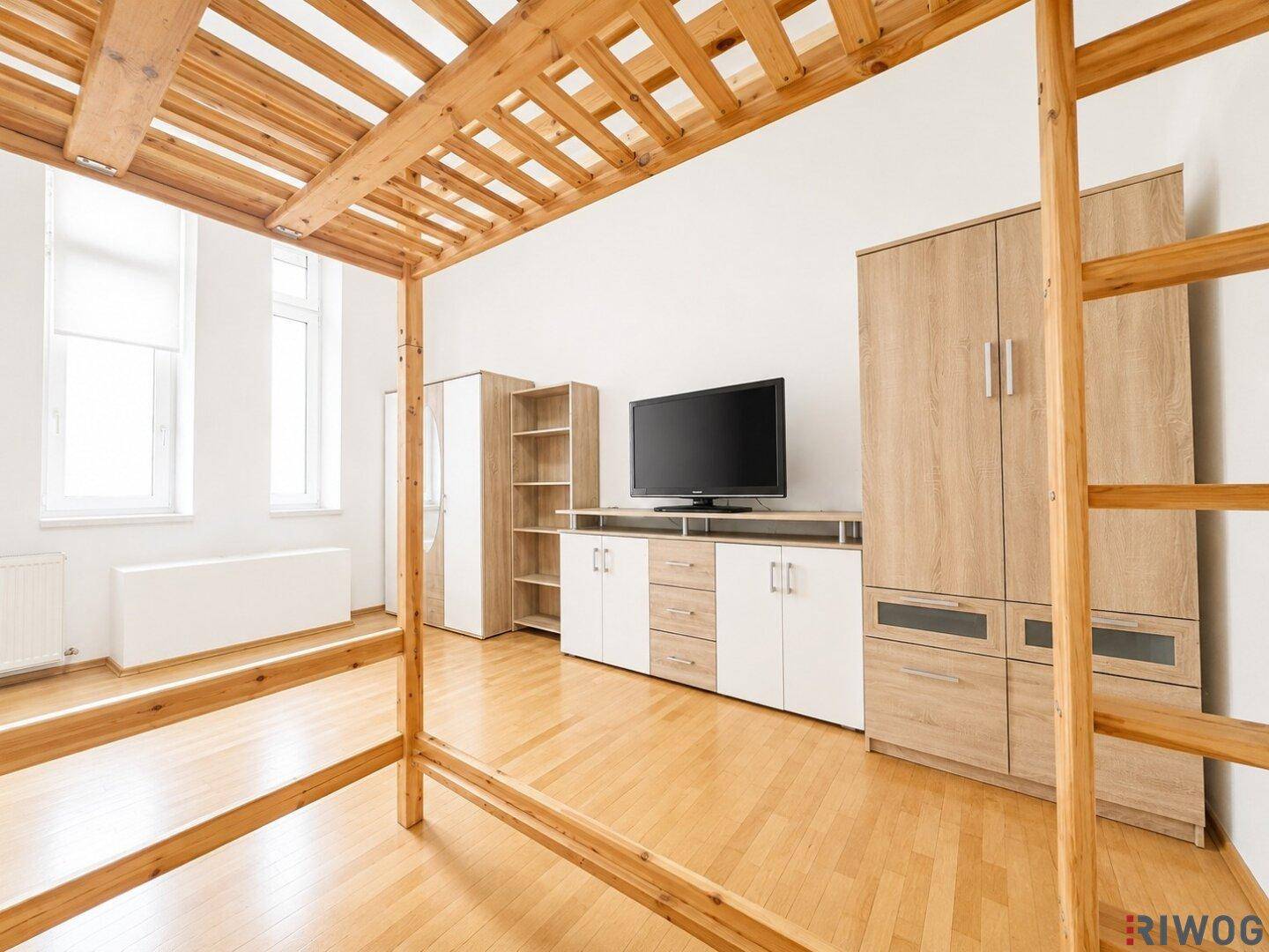 Helles Schlafzimmer mit Holzboden, Etagenbett und modernen Holzmöbeln, inklusive Fernseher.