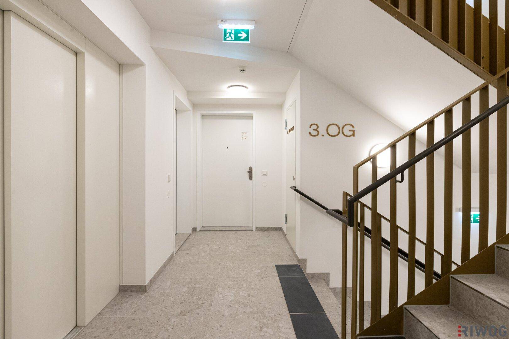 Heller Flur im dritten Obergeschoss mit Zugang zu den Wohnungen, Aufzug und Treppenhaus.