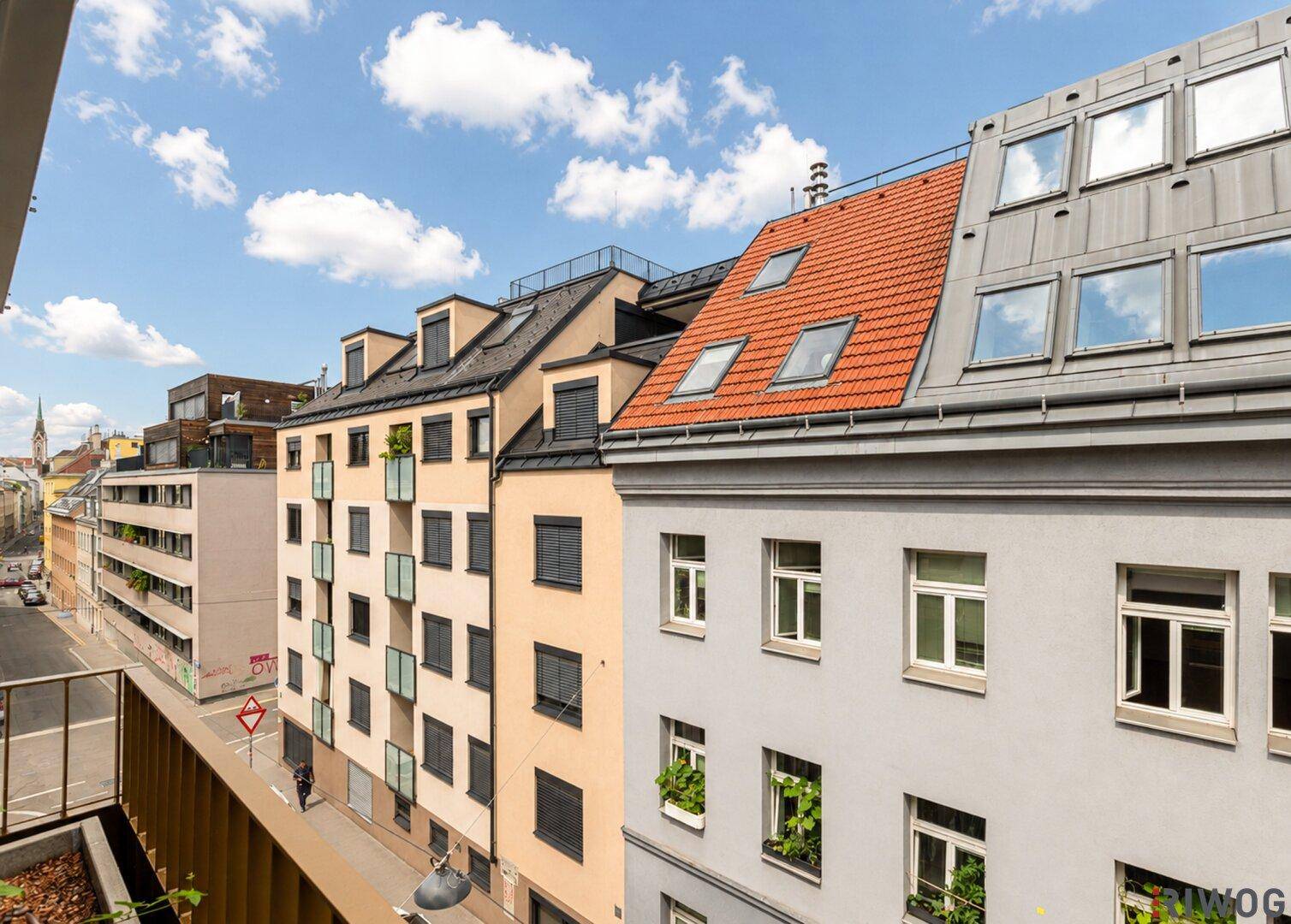 Ausblick von einem Balkon auf die umliegenden Gebäude und die Stadtstraße.