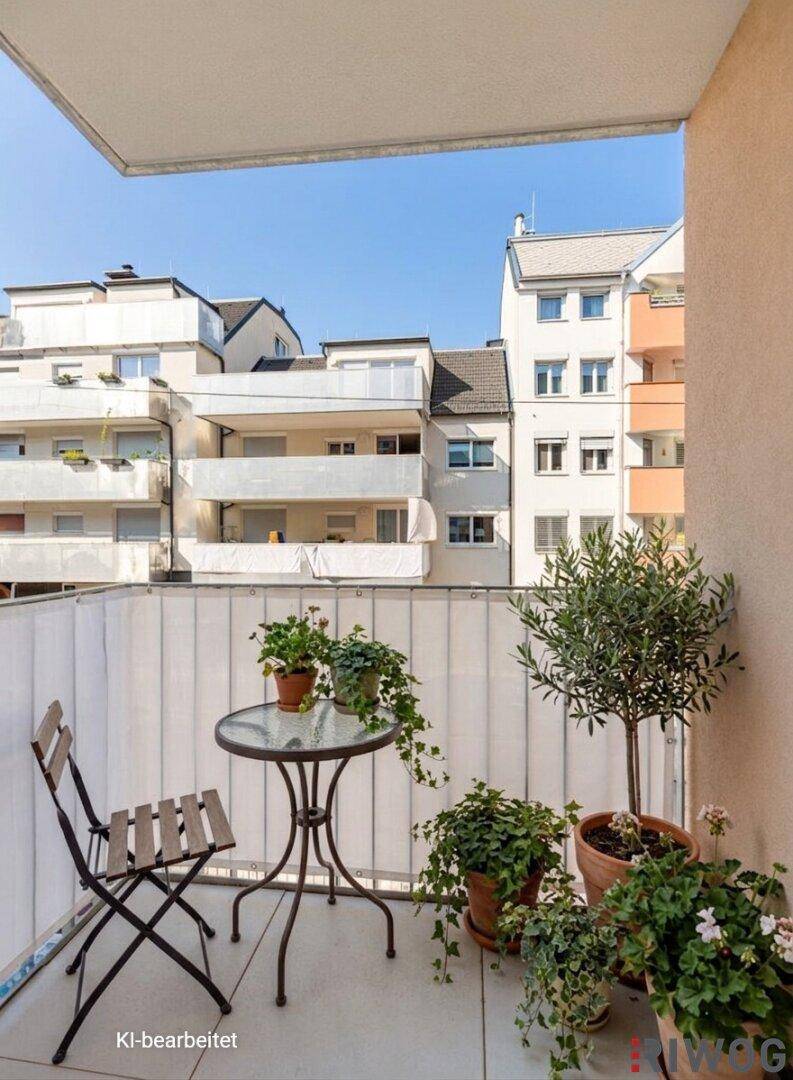 Gemütlicher Balkon mit Sitzgelegenheiten und Pflanzen, bietet einen Blick auf umliegende Wohngebäude.
