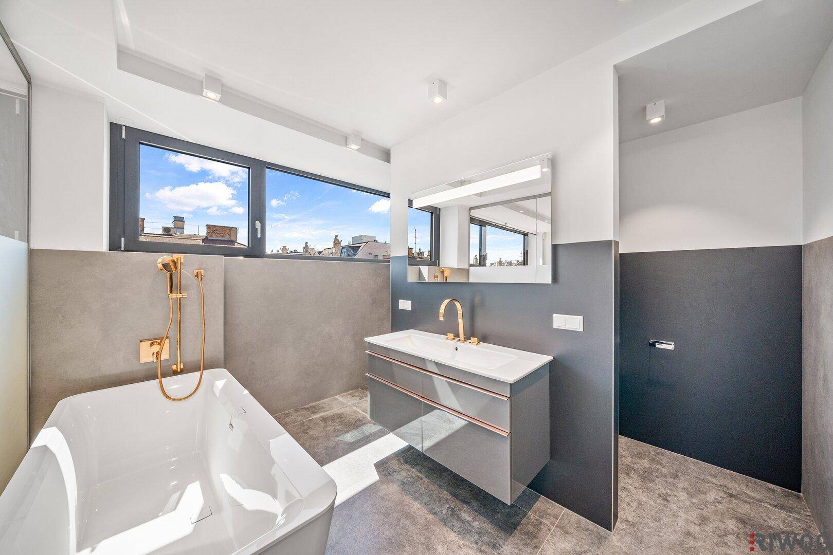 Elegantes Badezimmer mit Badewanne, Einzelwaschbecken und Fenster, das Tageslicht spendet.