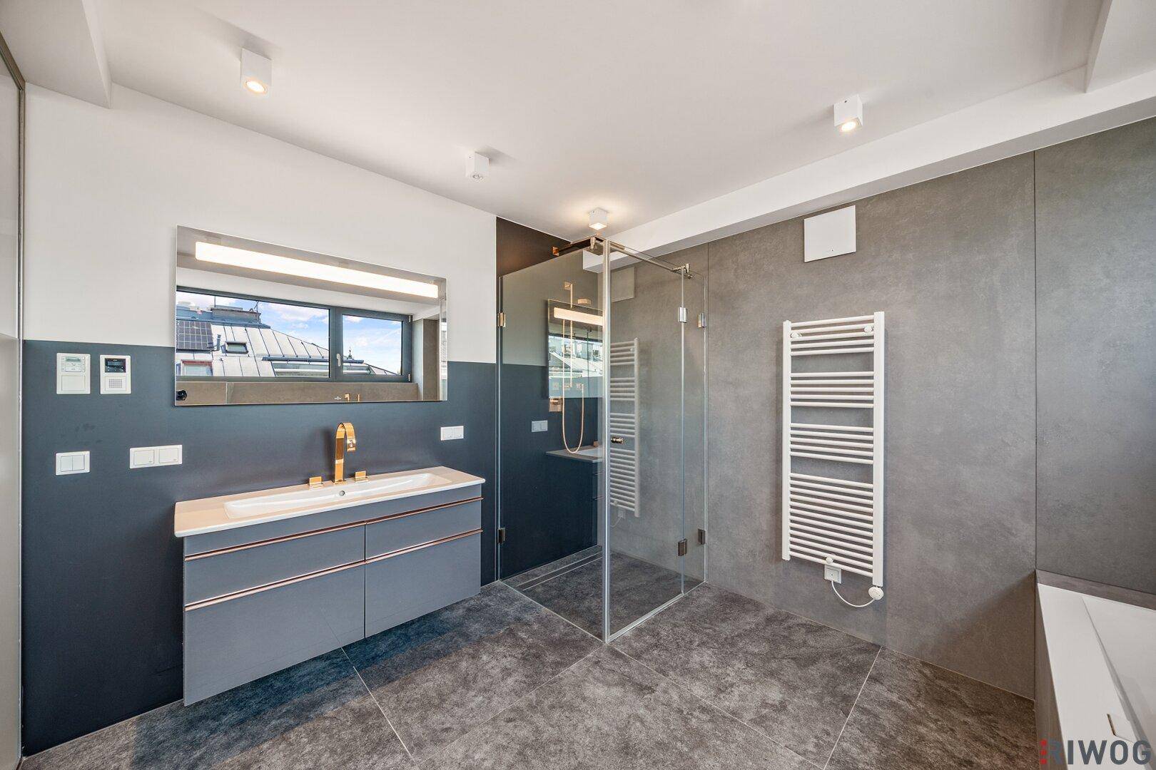 Modernes Badezimmer mit Einzelwaschbecken, begehbarer Dusche und großem Spiegel.