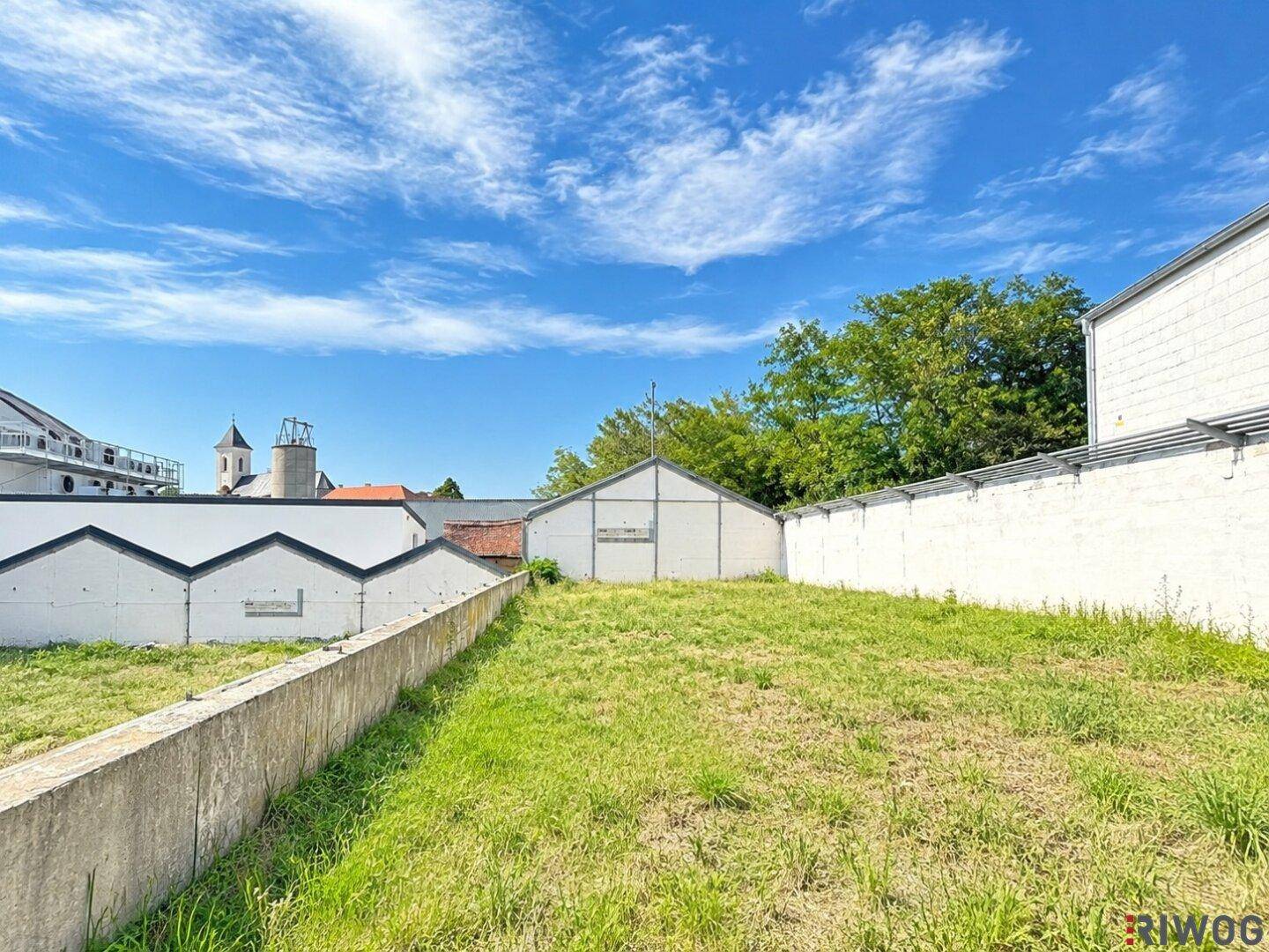 Große Grünfläche mit Rasen und Blick auf umliegende Gebäude und den Himmel.