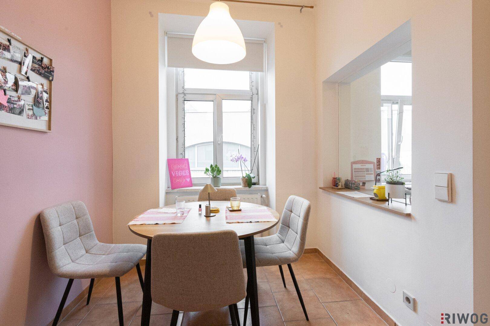 Gemütlicher Essbereich mit rundem Tisch, vier Stühlen und Fensterblick, ideal für Mahlzeiten.