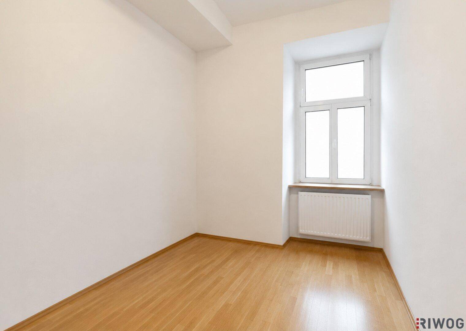 Kleiner, heller Raum mit Holzboden und einem Fenster, ideal als Kinderzimmer oder Büro.