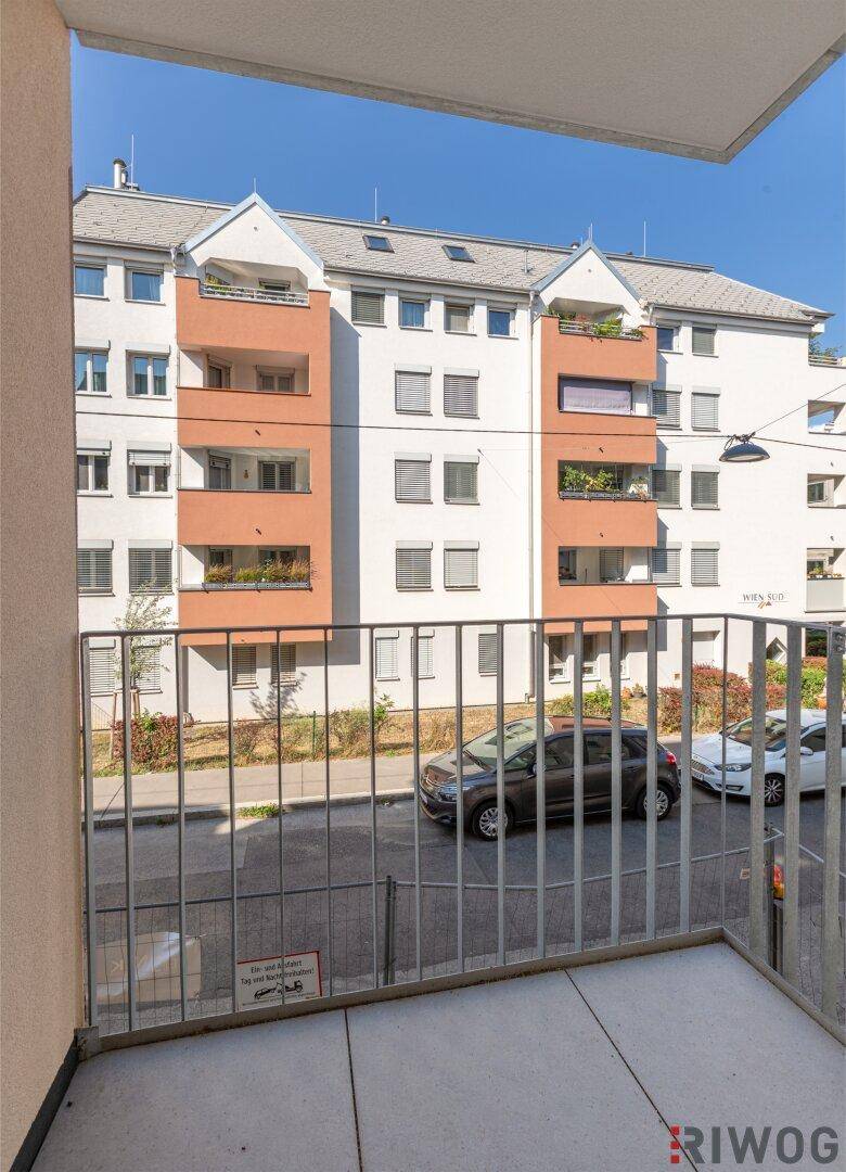 Blick von einem Balkon auf die gegenüberliegende Wohnbebauung und die Straße.