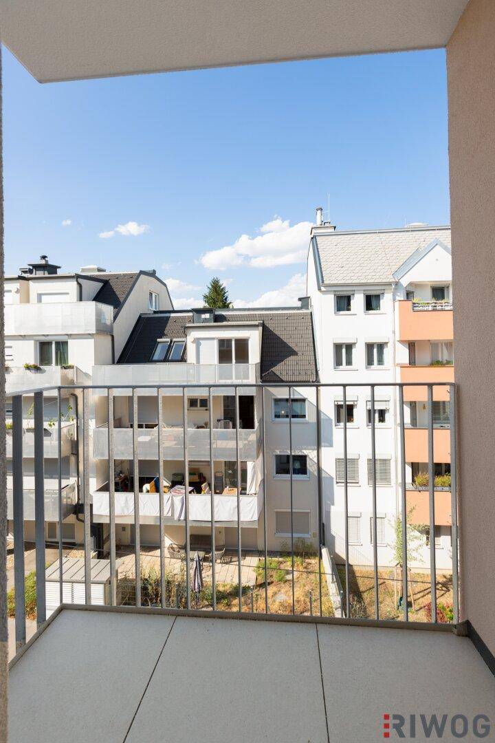 Heller Balkon mit Metallgeländer und Blick auf die umliegenden Gebäude.